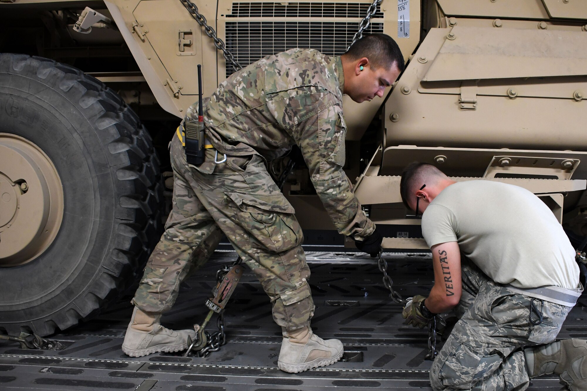 Tech Sgt. Ronald Gowen, a 387th Air Expeditionary Squadron logistician, left, helps Staff Sgt. Dylan Collins, a 386th Expeditionary Logistics Readiness Squadron aerial porter, right, with securing a mine-resistant ambush-protected vehicle in the cargo area of a C-17 Globemaster III at an undisclosed location in Southwest Asia Nov. 4, 2016. Gowen is currently embedded with  the 386th Expeditionary Logistics Readiness Squadron as he awaits transfer to a joint unit. 