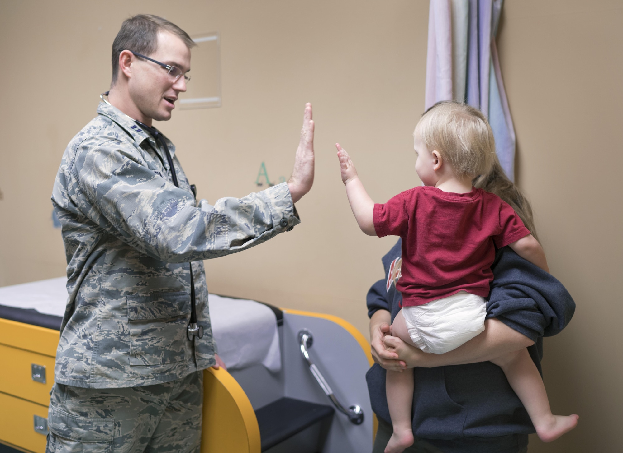 Capt. Michael Guindon, 374th Medical Group pediatrician, gives a high five to a patient Nov. 2, 2016, at Yokota Air Base, Japan. The clinic works around the clock to provide a full range of children's healthcare services to keep kids healthy. (U.S. Air Force photo by Senior Airman Delano Scott/Released)