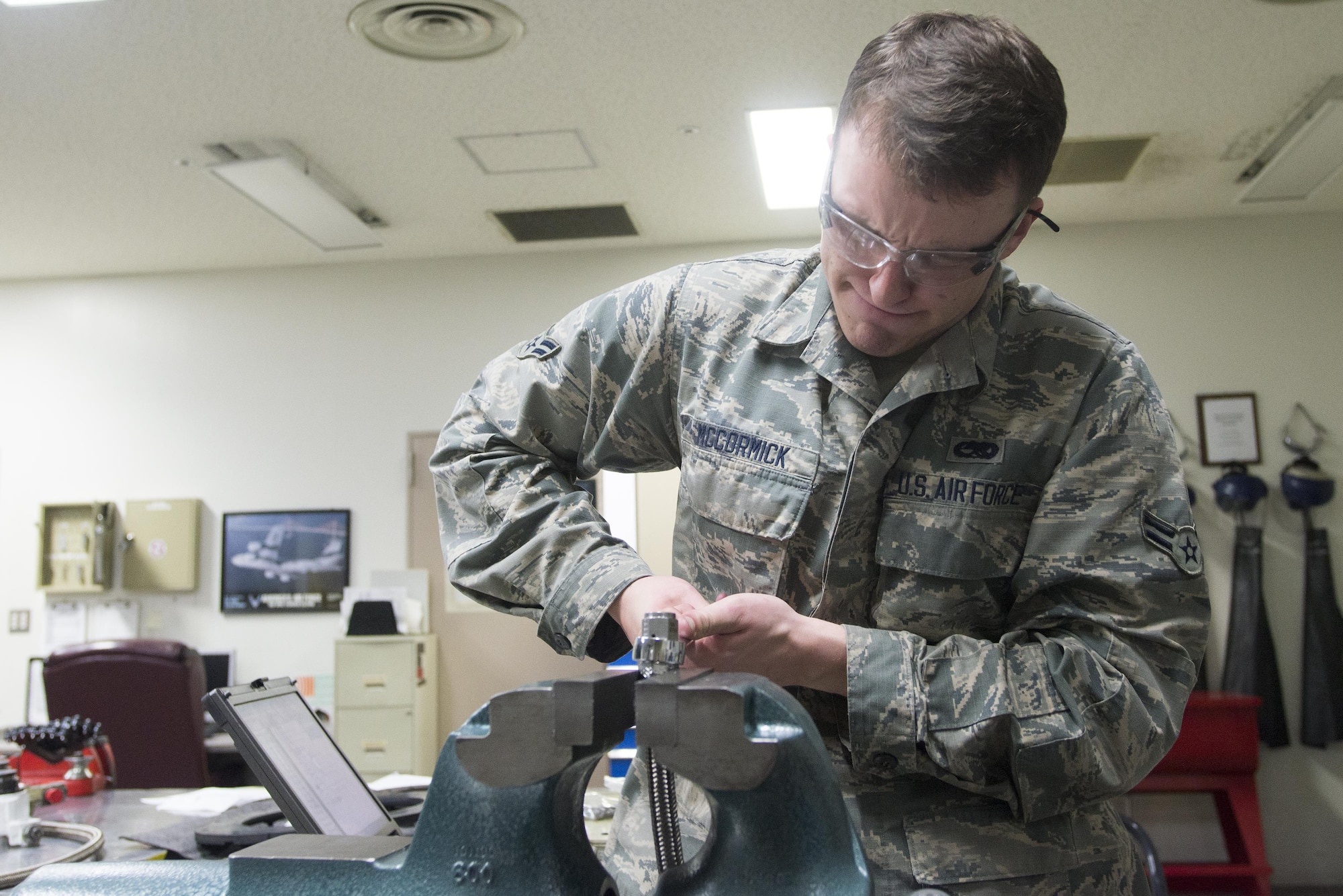Airman 1st Class Hudson McCormick, 374th Maintenance Squadron aircraft hydraulics journeyman, tightens a bolt onto a hose in preparation for testing at Yokota Air Base, Japan, Nov. 8, 2016. Each length of hose is tested before use to ensure that there are no defects. (U.S. Air Force photo by Senior Airman David C. Danford/Released)