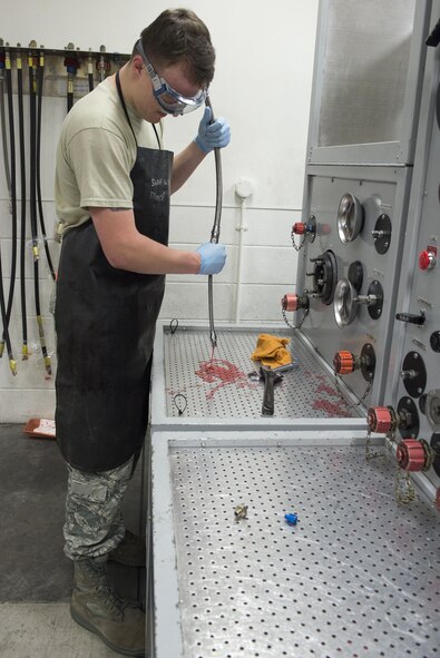 Airman 1st Class Hudson McCormick, 374th Maintenance Squadron aircraft hydraulics journeyman, drains hydraulics testing fluid from a hose at Yokota Air Base, Japan, Nov. 8, 2016. The hydraulics shop is part of the accessories flight which also includes the fuels maintenance and electrical and environmental shops. (U.S. Air Force photo by Senior Airman David C. Danford/Released)