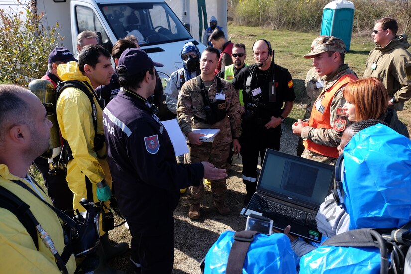 Center, U.S. Army Capt. Dino de la Hoya an operations officer with the 773rd Civil Support Team, 7th Mission Support Command listens to Aram Jalatyan, Armenia CBRN Division Nov. 2, 2016, during the NATO EADRCC Consequence Management Field Exercise "CRNA GORA 2016."