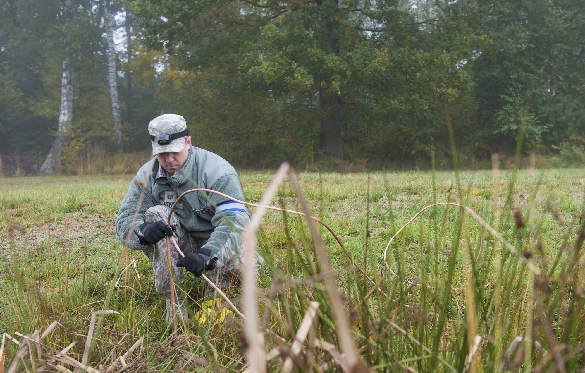 Tech. Sgt. Michael Lewis, 1st Combat Communications Squadron heating, ventilation and air conditioning technician, lays ground wires during exercise Healthy Thunder at Ramstein Air Base, Germany, Oct. 27, 2016. During the two-week exercise, the 1st CBCS Airmen set up communications in a bare-base environment and defended their site from opposing forces to prepare them for a deployment. (U.S. Air Force photo by Senior Airman Tryphena Mayhugh)
