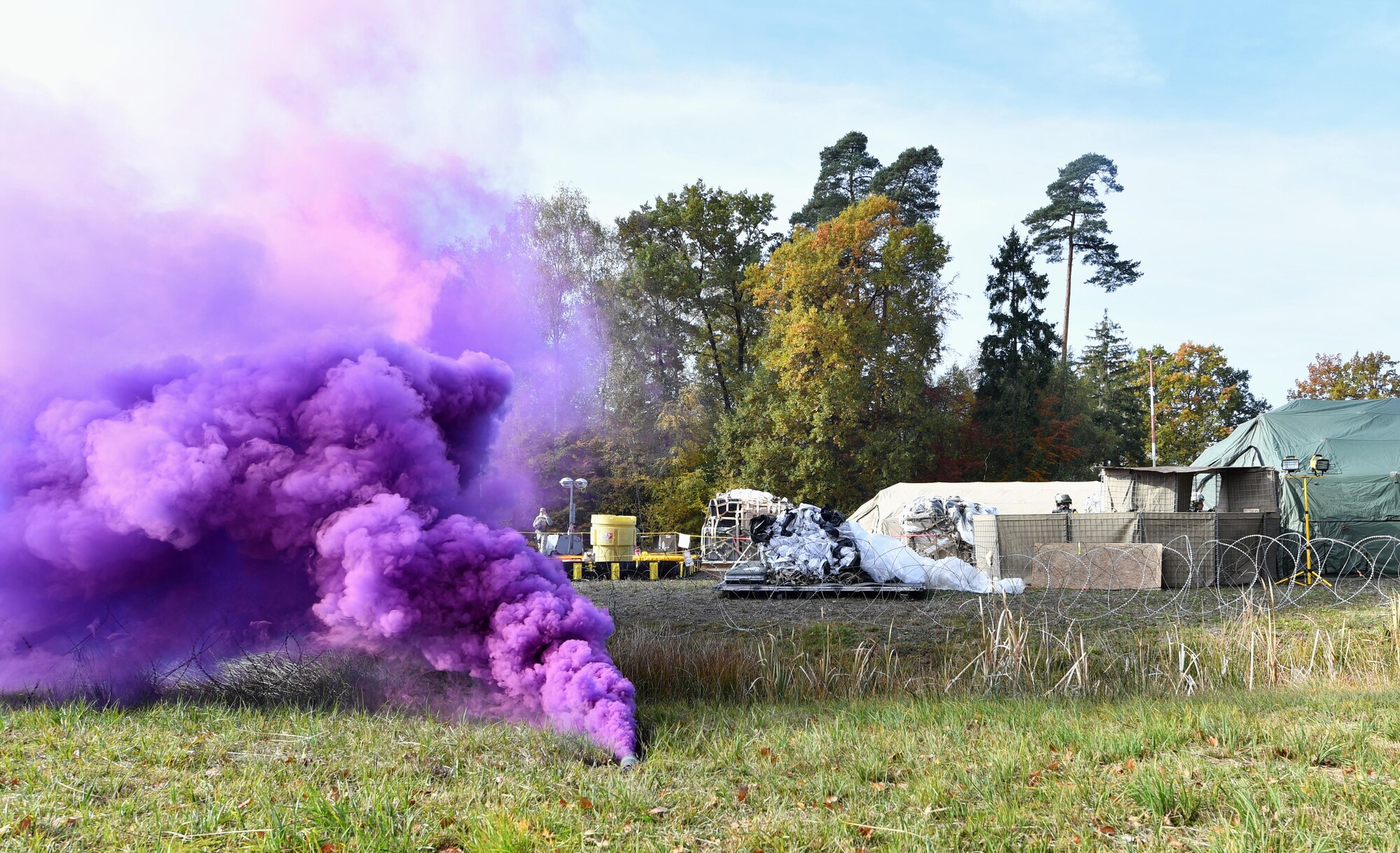 Purple smoke pours out of a smoke grenade during exercise Healthy Thunder at Ramstein Air Base, Germany, Nov. 3, 2016. Airmen assigned to the 1st Combat Communications Squadron participated in the exercise to prepare them for a deployment. (U.S. Air Force photo by Senior Airman Tryphena Mayhugh)