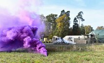 Purple smoke pours out of a smoke grenade during exercise Healthy Thunder at Ramstein Air Base, Germany, Nov. 3, 2016. Airmen assigned to the 1st Combat Communications Squadron participated in the exercise to prepare them for a deployment. (U.S. Air Force photo by Senior Airman Tryphena Mayhugh)