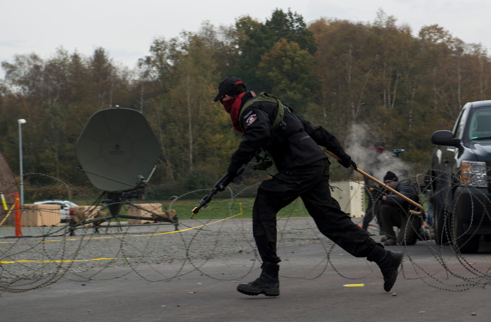 An Airman assigned to the 1st Combat Communications Squadron uses a cane to remove Constantine wire during exercise Healthy Thunder at Ramstein Air Base, Germany, Nov. 4, 2016. Several 1st CBCS Airmen played the role of opposing forces during the exercise and attacked the base in a variety of ways. (U.S. Air Force photo by Senior Airman Tryphena Mayhugh)