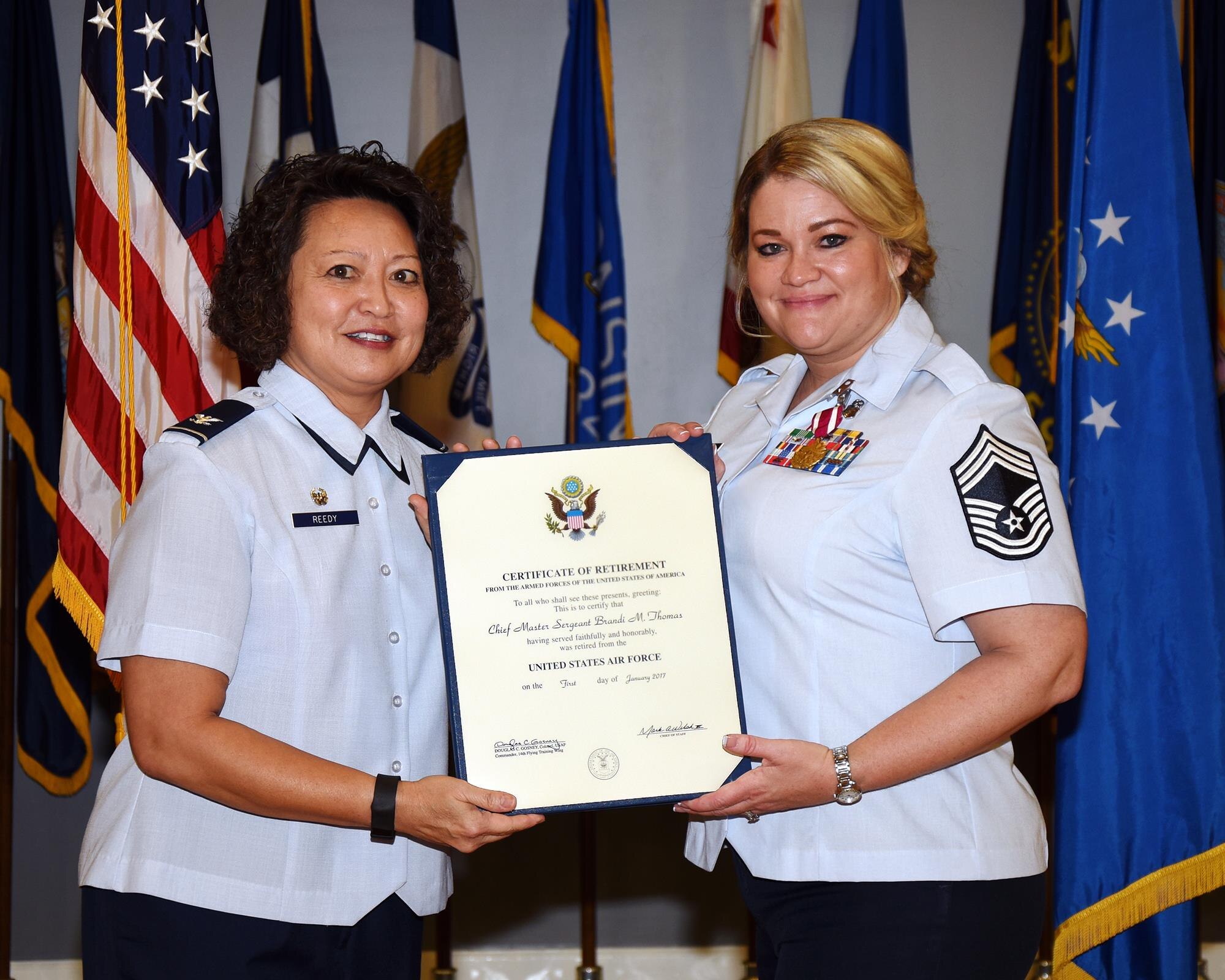 Col. Imelda Reedy, 14th Medical Group Commander, presents Chief Master Sgt. Brandi Thomas, 14th MDG Superintendent, with her certificate of retirement Nov. 4 at Columbus Air Force Base, Mississippi. Thomas served for 23 years in the military. (U.S. Air Force photo by Sharon Ybarra)