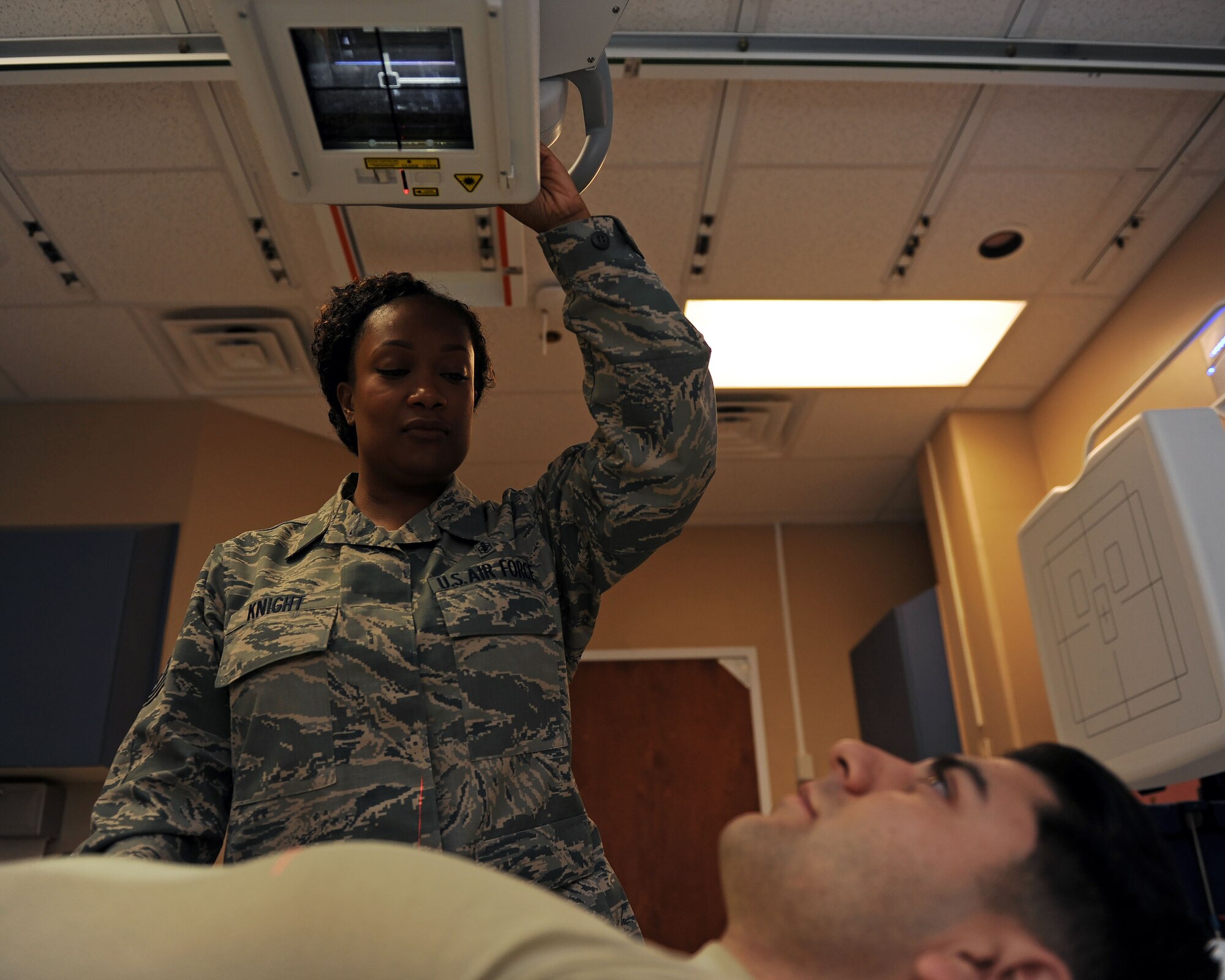 Tech. Sgt. Anissa Knight, 27th Special Operations Medical Support Squadron NCO-in charge of diagnostic imaging, simulates taking an X-ray with the assistance of Senior Airman Efren Armenta Herrera, 27th SOMDSS diagnostic imagining technologist, at 27th Special Operations Medical Group, Oct. 25, 2016. Diagnostic imaging technologists assist physicians by taking comprehensive X-rays of afflicted body parts in settings ranging from surgery centers to imaging rooms. These professionals utilize highly sophisticated equipment and an intimate knowledge of human anatomy to help generate reliable imagery and treat their patients. (U.S. Air Force photo/Staff Sgt. Whitney Amstutz/released)