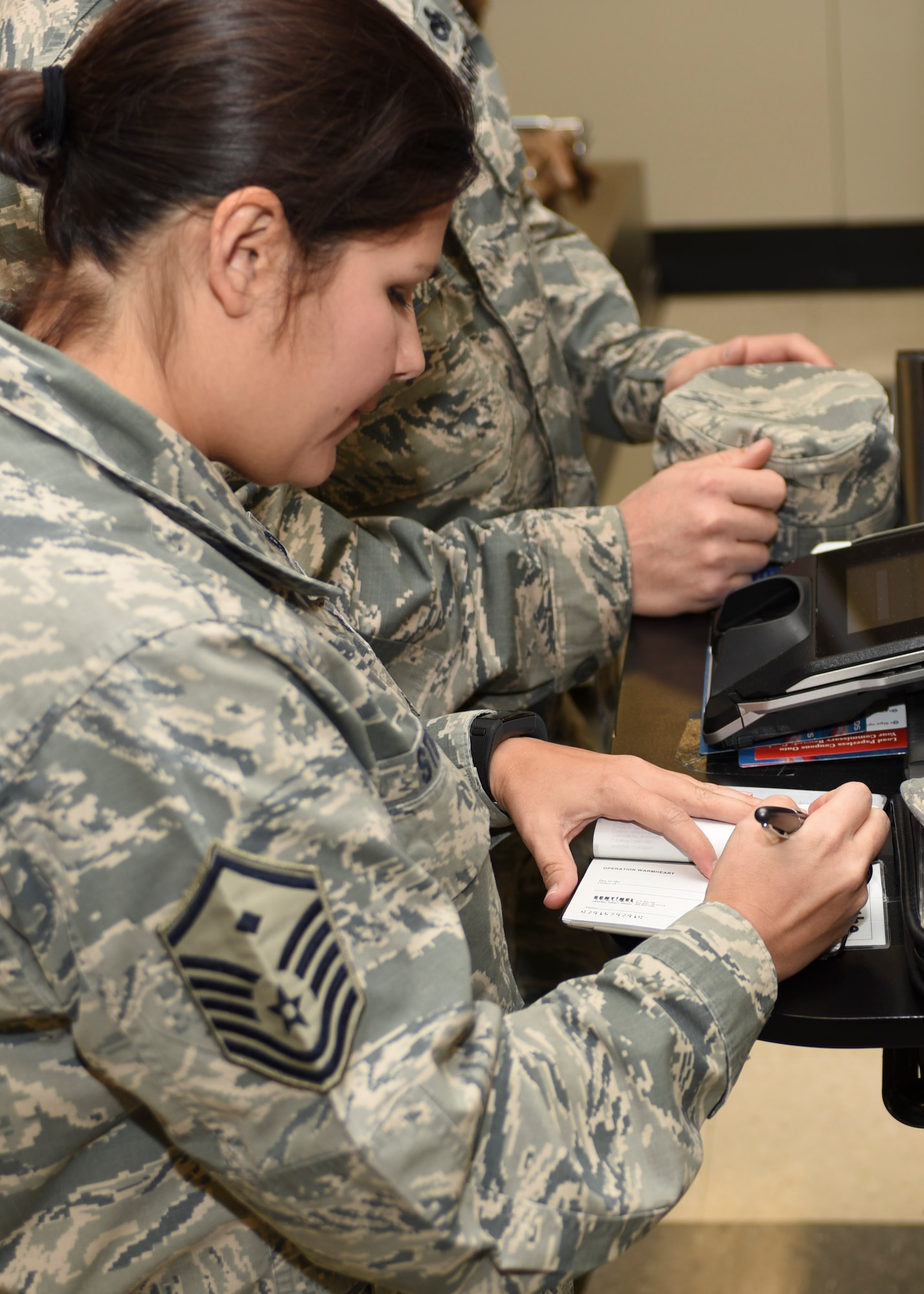 From the donations collected, Master Sgt. Toni Stokes, 28th Comptroller Squadron and Bomb Wing Staff first sergeant, writes a check out inside the Commissary at Ellsworth Air Force Base, S.D., on Nov. 8, 2016. As part of Operation Warm Heart, the $2,500.00 check purchased 100 $25 gift cards that the First Sergeants’ Council will give to Airmen in need during the holiday season.(U.S. Air Force photo by Airman 1st Class Randahl J. Jenson)