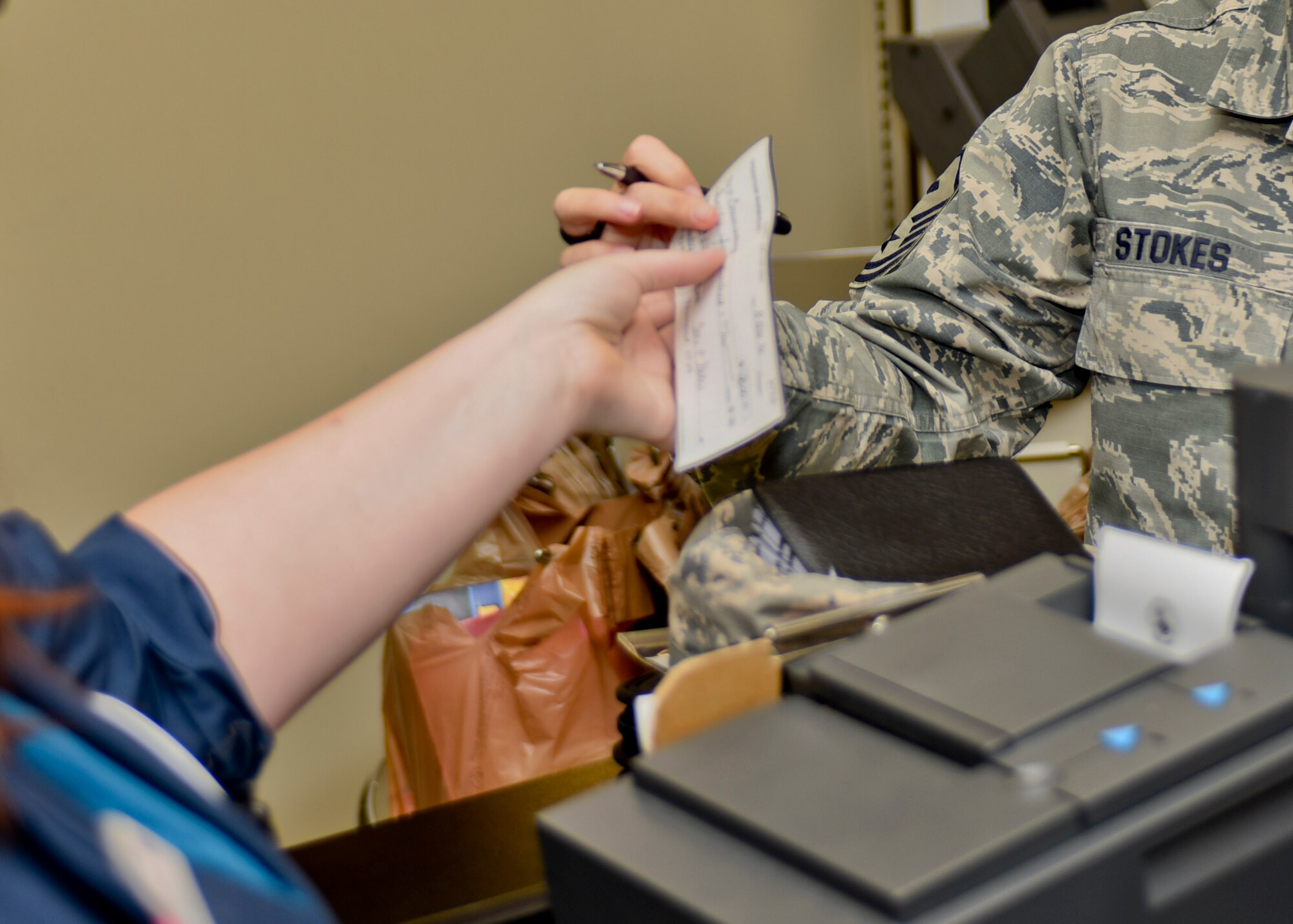 Master Sgt. Toni Stokes, 28th Comptroller Squadron and Bomb Wing Staff first sergeant, gives Sarah Croston, a cashier at the Commissary, a check purchasing $2,500.00 worth of Commissary Gift Cards at Ellsworth Air Force Base, S.D., on Nov. 8, 2016. With donated funds collected by The First Sergeants’ Council, 100 Commissary gift cards were purchased for Operation Warm Heart, a yearly program designed to assist Airmen in need during the holiday season. (U.S. Air Force photo by Airman 1st Class Randahl J. Jenson)
