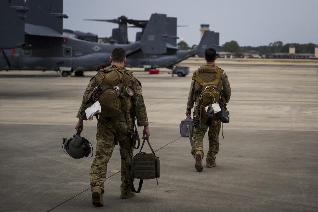Flight engineers with the 8th Special Operations Squadron, walk to a CV-22 Osprey tiltrotor aircraft at Hurlburt Field, Fla., Nov. 8, 2016. Flight engineers perform pre-flight inspections of aircraft and monitor their engines and other critical flight systems while flying. (U.S. Air Force photo by Airman 1st Class Joseph Pick)