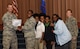 Senior Airman Kitana Grable, 2nd Security Force Squadron installation access controller, is presented with a certificate of promotion with her family at Barksdale Air Force Base, La., November 2, 2016. Kitana’s mother and three siblings lost their home in Macon, Ga., to a house fire July 3. The Grable family has since moved to Barksdale, where Kitana has taken them in and is helping support them. (U.S. Air Force photo/Airman Alexis Schultz)