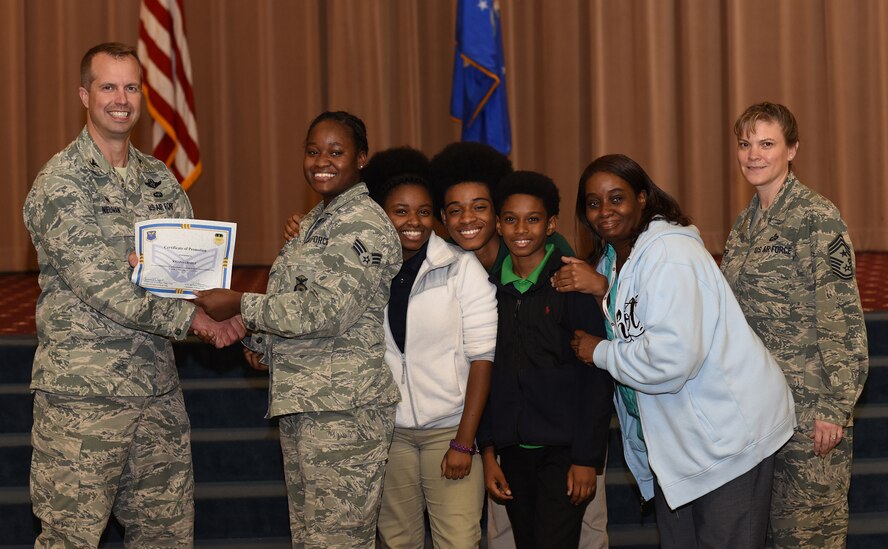 Senior Airman Kitana Grable, 2nd Security Force Squadron installation access controller, is presented with a certificate of promotion with her family at Barksdale Air Force Base, La., November 2, 2016. Kitana’s mother and three siblings lost their home in Macon, Ga., to a house fire July 3. The Grable family has since moved to Barksdale, where Kitana has taken them in and is helping support them. (U.S. Air Force photo/Airman Alexis Schultz)