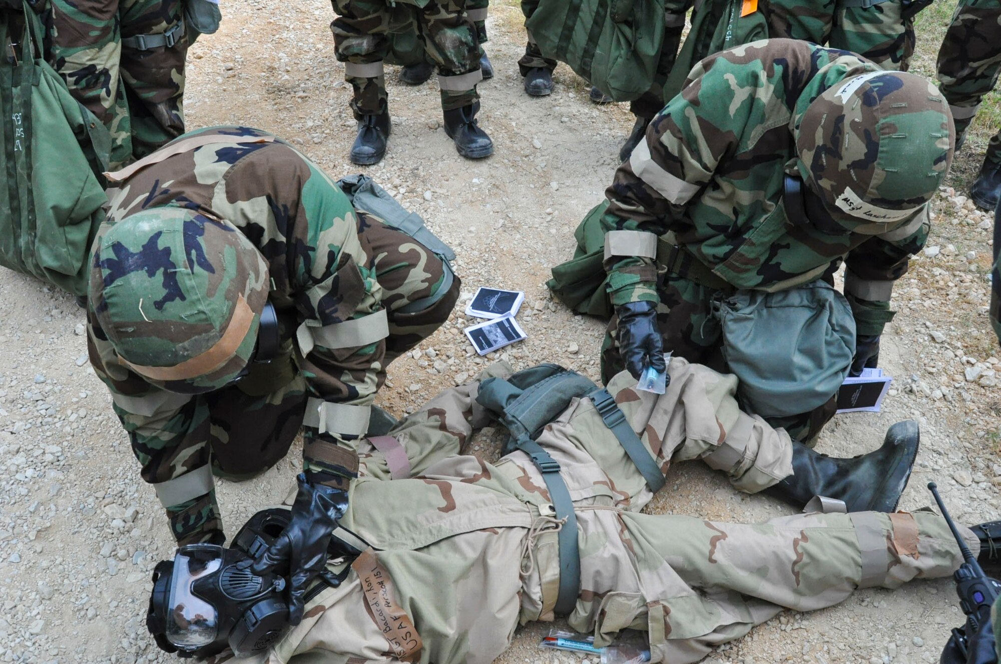 Members of the 433rd Airlift Wing check the status of a downed Airmen who had been exposed to a chemical agent during the Steel Thunder exercise Nov. 5, 2016 at Joint Base San Antonio-Lackland. Members were required to assess the situation and provide the appropriate self-aid and buddy care while remaining in full Mission Oriented Protective Posture gear during the exercise. (U.S. Air Force photo/Senior Airman Bryan Swink)