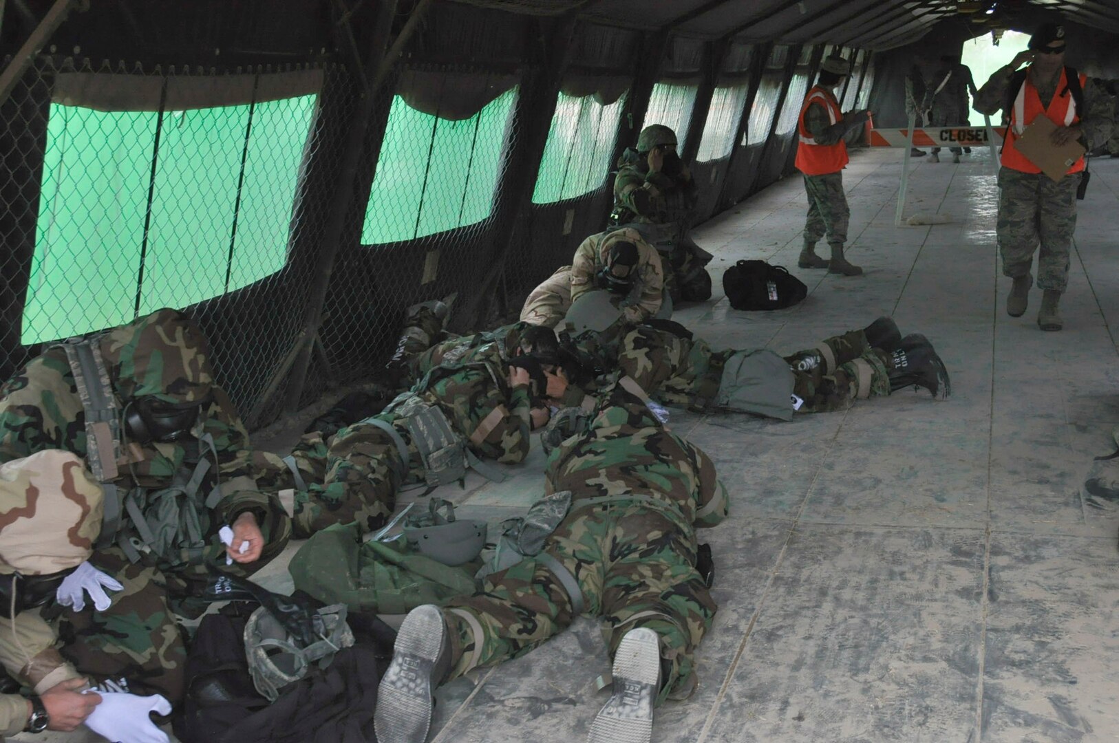 Members of the 433rd Operations Group react to a simulated attack by dropping to the ground and putting on their Mission Oriented Protective Posture gear during the Steel Thunder exercise Nov. 5, 2016 at Joint Base San Antonio-Lackland. Members were also required to observe what was going on during the attack and report it accurately. (U.S. Air Force photo/Senior Airman Bryan Swink)