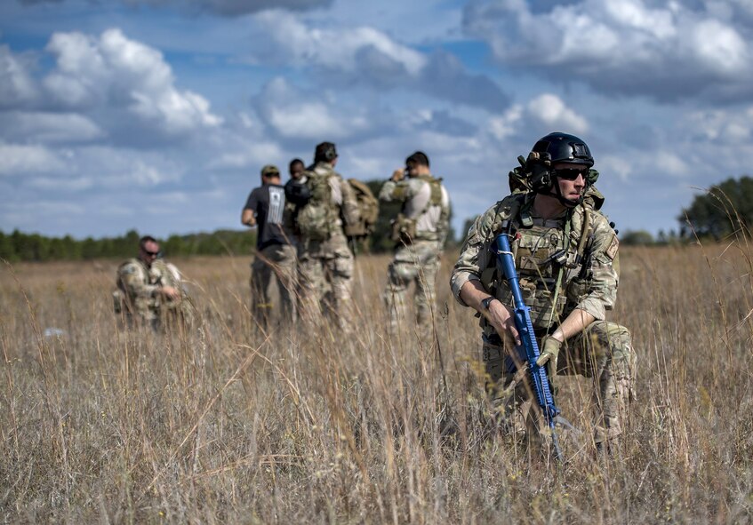 A pararescueman from the 38th Rescue Squadron watches his sector as others pack their parachutes during a rapid-rescue exercise, Nov. 2, 2016, in Marianna, Fla. The pararescuemen specialize in survivor contact, treatment and extraction in denied, uncertain and hostile territories. (U.S. Air Force photo by Tech.  Sgt. Zachary Wolf)