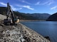 A backhoe moves along Hills Creek Dam as part of ongoing IES field investigation work.