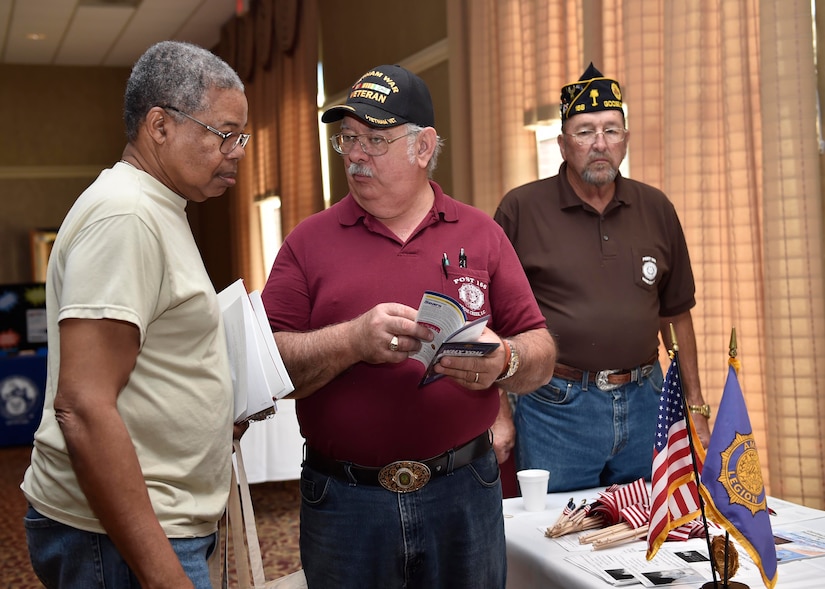 Pal Johnson, a U.S. Navy veteran, left, receives a briefing from Dean Nimocks, American Legion representative, during a veteran's appreciation event at the Red Bank Club here, Nov. 10, 2016. The inaugural appreciation day provided the opportunity for organizations such as Tricare, the American Legion and the 628th Medical Group to educate veterans and retirees about their benefits.