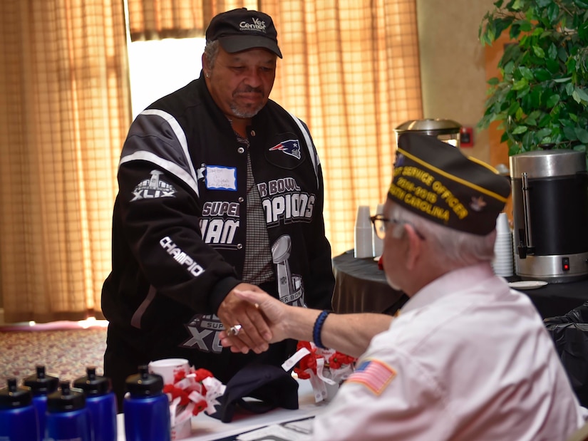 Clayton Givens, a U.S. Marine Corps veteran, left, shakes hands with Phil Cates, a U.S. Army veteran with the Ralph H. Johnson Veterans Association Medical Center, during a veteran's appreciation event at the Red Bank Club here, Nov. 10, 2016. The inaugural appreciation day provided the opportunity for organizations such as Tricare, the American Legion and the 628th Medical Group to educate veterans and retirees about their benefits.