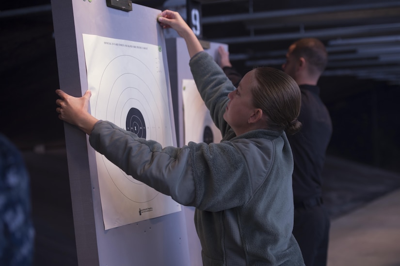 Airman Gabrielle Spalding, 11th Wing Public Affairs photojournalist, hangs up a target during the 2nd Annual Excellence in Competition on Joint Base Andrews, Nov. 8, 2016. Service members were broken into relays to allow everyone who signed up the chance to participate and test their marksmanship, with each member shooting 30 rounds from a Beretta M9 pistol. Targets were scored by combat arms instructors, and then compared to determine the best marksman. (U.S. Air Force photo by Senior Airman Mariah Haddenham)