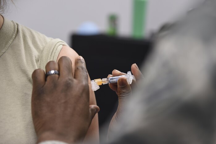 An annual flu vaccine is given to a member of Joint Base Charleston at a point of distribution during a public health emergency exercise on Joint Base Charleston, South Carolina, Nov. 9, 2016.  In the event of a real world incident, members would be given a flu vaccine if they hadn’t already received one, as well as medication to combat the outbreak. To simulate that, those who participated in the exercise were given the vaccination and candy to represent the medication.