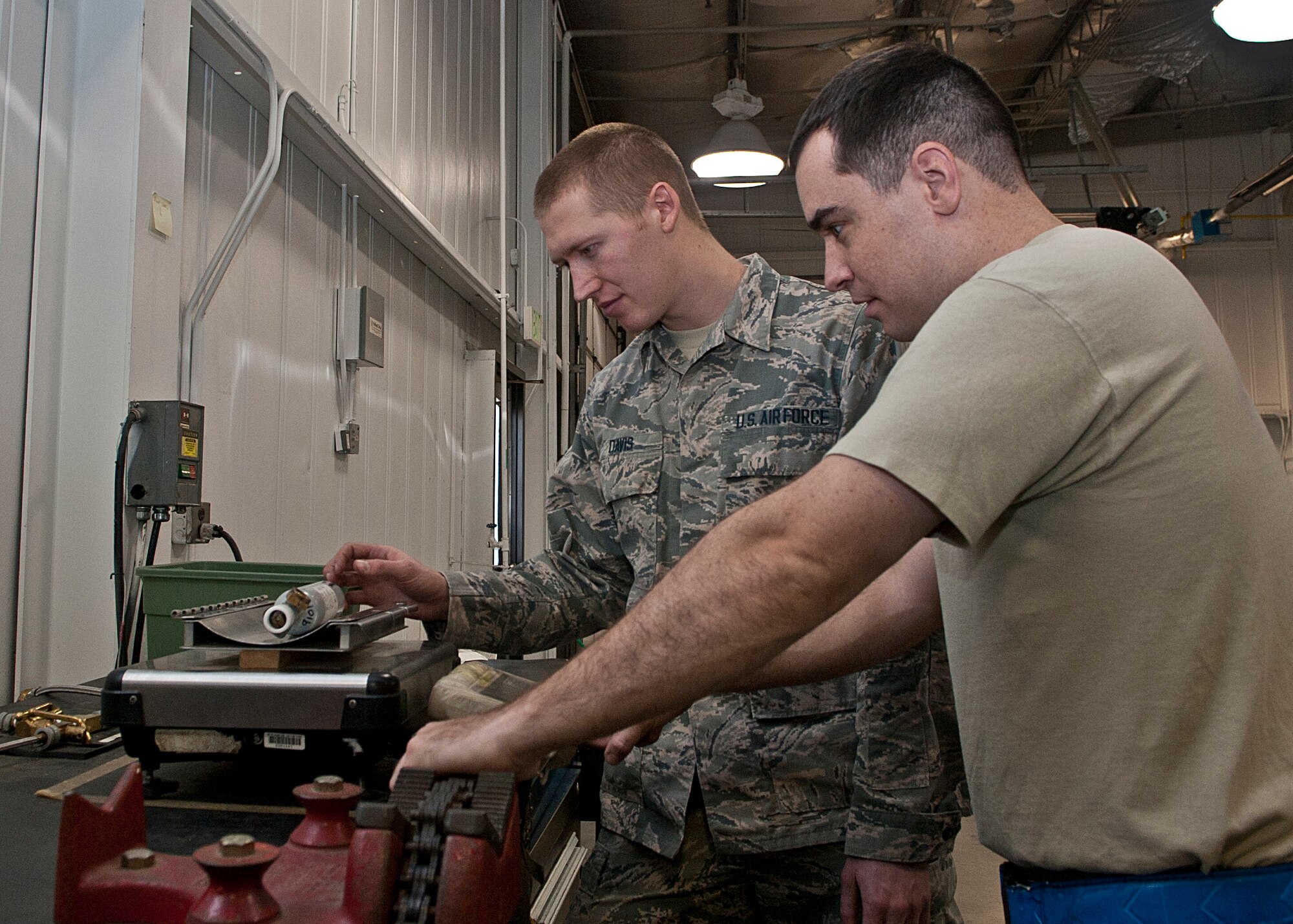 (From left) Airman 1st Class Joshua Davis, 5th Maintenance Squadron electrical and environmental apprentice, and Staff Sgt. Christopher Thomann, 5 MXS electrical and environmental craftsman, check a raft bottle’s weight at Minot Air Force Base, N.D., Nov. 2, 2016. Raft bottles are used to inflate aircrew life rafts during an emergency situation. (U.S. Air Force photo/Airman 1st Class Jonathan McElderry)