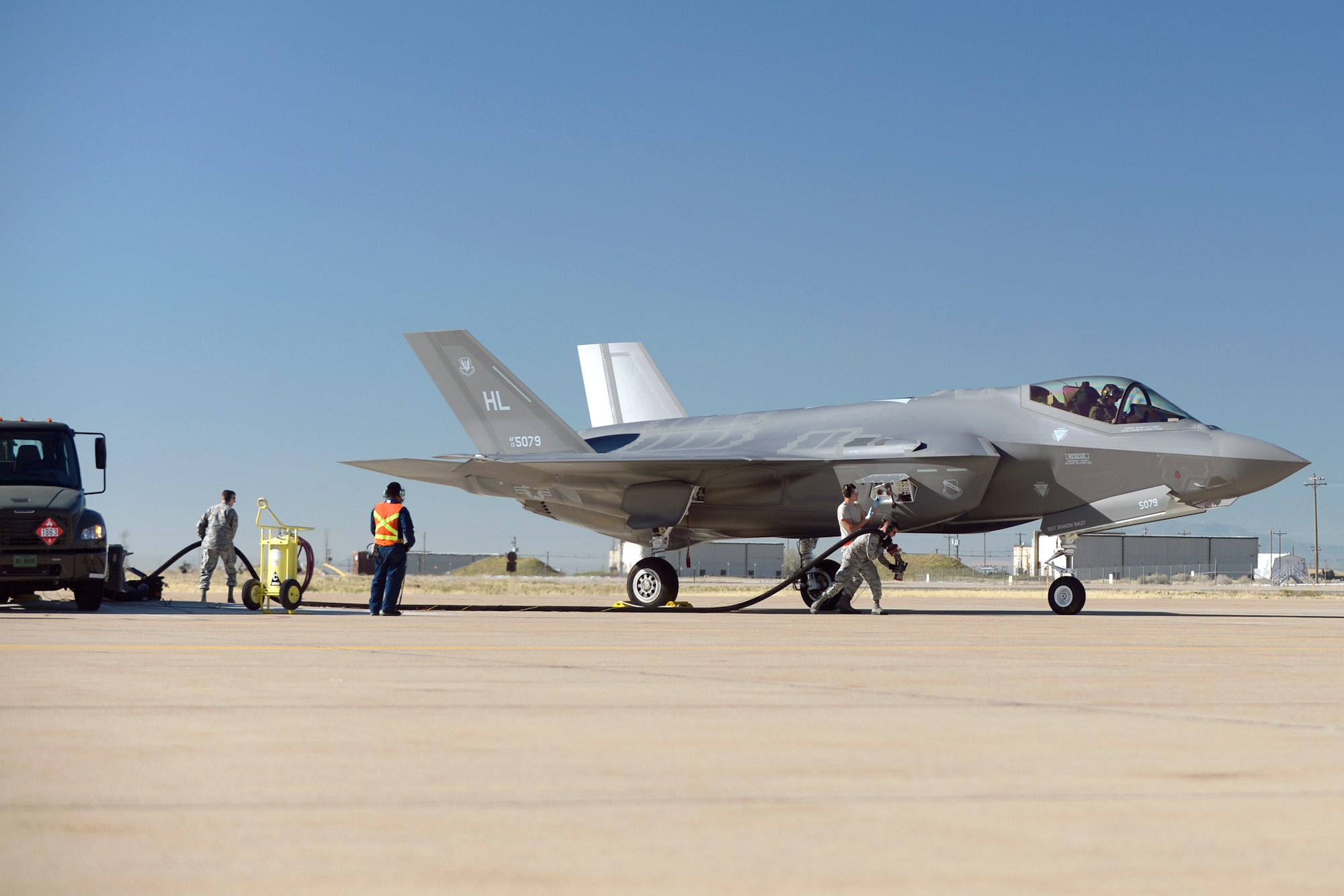 Airmen assigned to the 34th Aircraft Maintenance Unit and 75th Logistics Readiness Squadron perform hot refueling operations on an F-35 Lightning II fighter jet Nov. 8 at Hill Air Force Base. Hot pits operations allow for a faster refueling process since the pilot does not have to shut down the aircraft.  (U.S. Air Force photo by Todd Cromar)