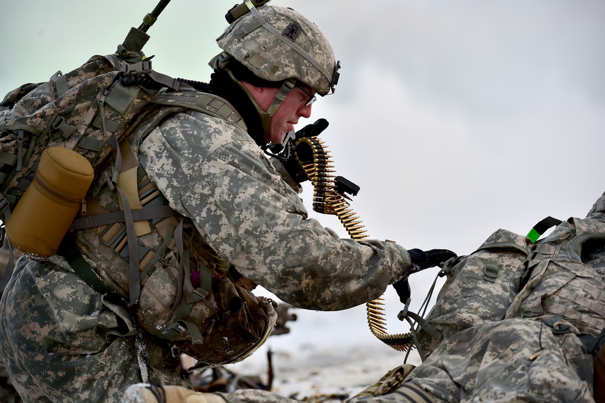 Army Staff Sgt. Samuel Hammer, assigned to Baker Company, 3rd Battalion, 509th Parachute Infantry Regiment, 4th Infantry Brigade Combat Team (Airborne), 25th Infantry Division, U.S. Army Alaska, pulls machine gun ammunition from a fellow paratrooper’s pack during live-fire and movement-to-contact operations on the Infantry Squad Battle Course at Joint Base Elmendorf-Richardson, Alaska, Nov. 8, 2016. The soldiers focused on core infantry skills such as fire team movement, communication, shifting fire, and once on the objective identifying and eliminating weapons caches and treating and evacuating casualties.  