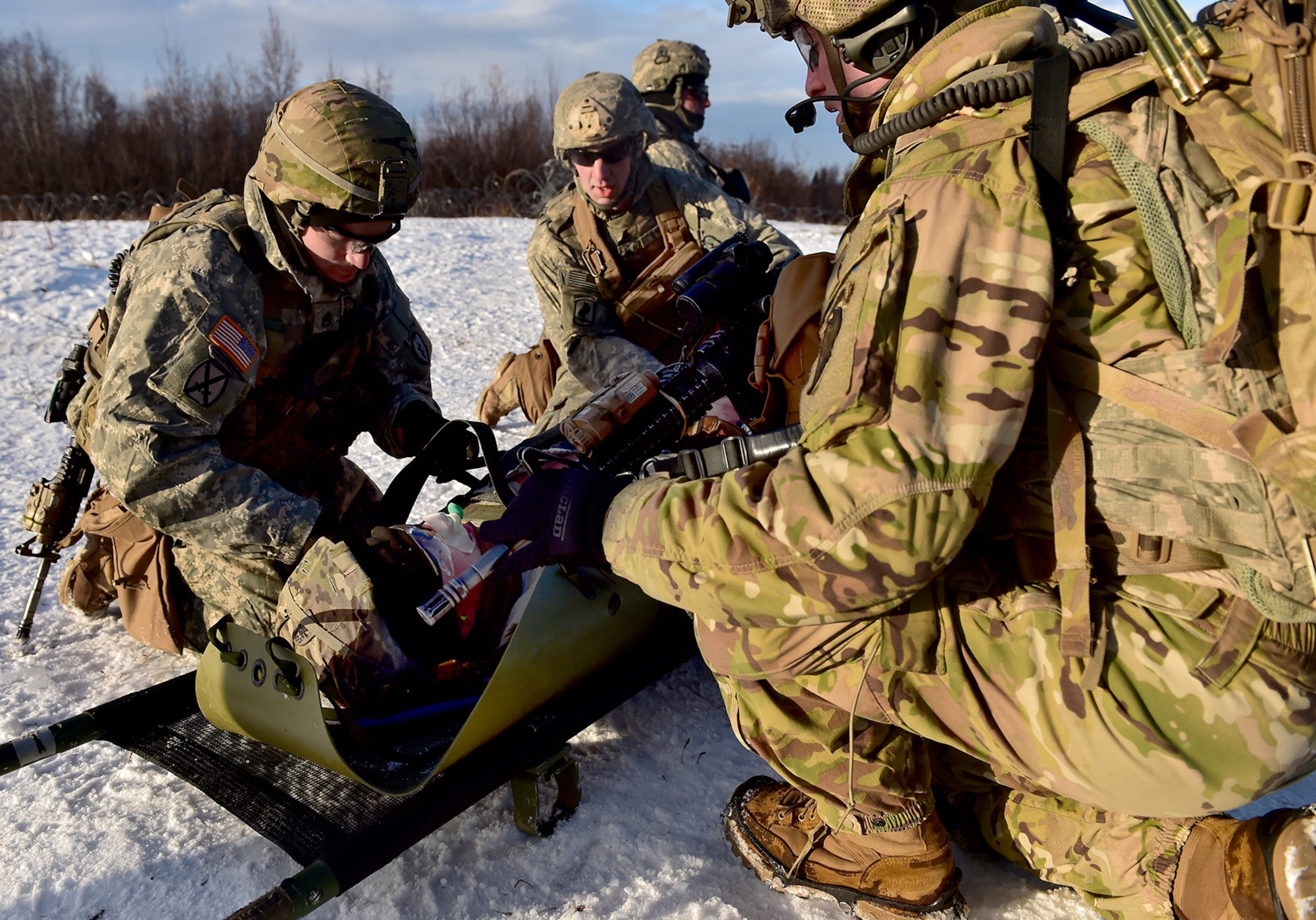 Paratroopers assigned to Baker Company, 3rd Battalion, 509th Parachute Infantry Regiment, 4th Infantry Brigade Combat Team (Airborne), 25th Infantry Division, U.S. Army Alaska, prepare to move a simulated casualty during live-fire and movement-to-contact operations on the Infantry Squad Battle Course at Joint Base Elmendorf-Richardson, Alaska, Nov. 8, 2016. The soldiers focused on core infantry skills such as fire team movement, communication, shifting fire, and once on the objective identifying and eliminating weapons caches and treating and evacuating casualties. 