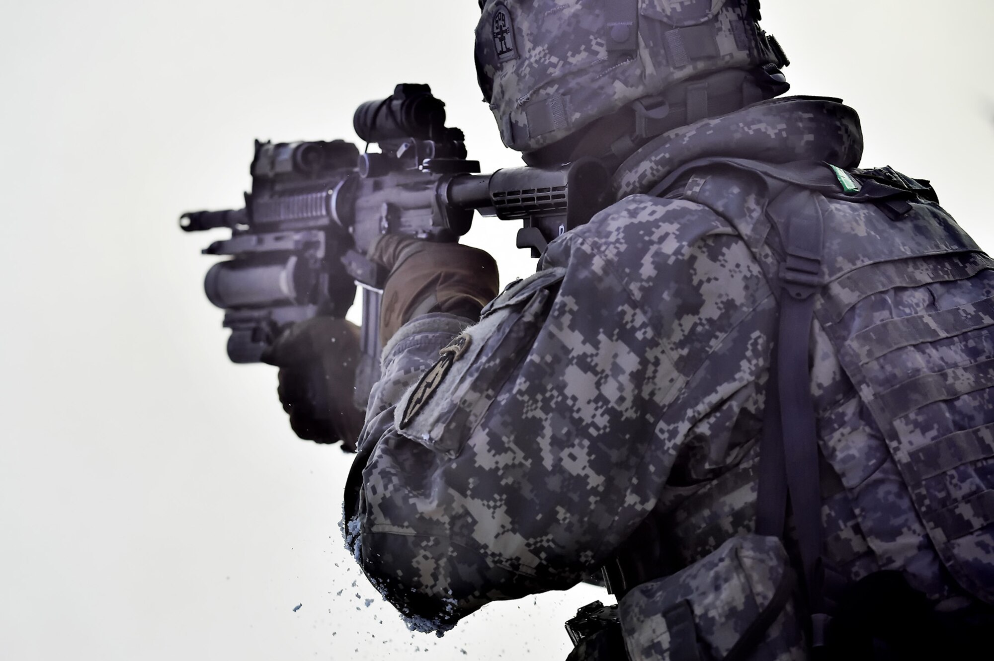 A paratrooper assigned to Baker Company, 3rd Battalion, 509th Parachute Infantry Regiment, 4th Infantry Brigade Combat Team (Airborne), 25th Infantry Division, U.S. Army Alaska, aims at a target through the cover of smoke during live-fire and movement-to-contact operations on the Infantry Squad Battle Course at Joint Base Elmendorf-Richardson, Alaska, Nov. 8, 2016. The soldiers focused on core infantry skills such as fire team movement, communication, shifting fire, and once on the objective identifying and eliminating weapons caches and treating and evacuating casualties.  (U.S. Air Force photo/Justin Connaher)
