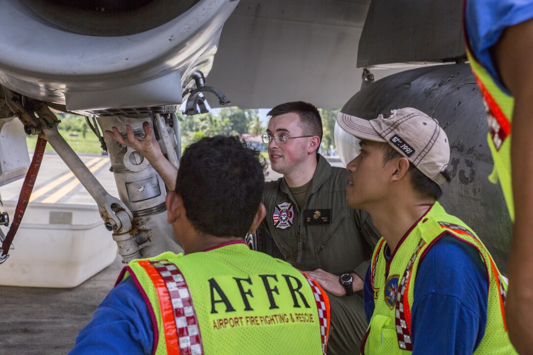 U.S. Marine Corps Sgt. Matthew Martel, Expeditionary Fire Rescue with Marine Wing Support Squadron (MWSS) 171, shows Indonesian Aircraft Rescue and Firefighting personnel different parts of an F/A-18D Hornet at Sam Ratulangi International Airport, Indonesia, Oct. 31, 2016. Marine All-Weather Fighter Attack Squadron (VMFA (AW)) 225 is participating in exercise Cope West 17, the first fighter-focused exercise in 19 years involving the U.S. Marine Corps and Indonesian Air Force. This fighter-focused, bilateral exercise is designed to enhance the readiness of combined interoperability between the two nations. (U.S. Marine Corps photo by Lance Cpl. Aaron Henson)