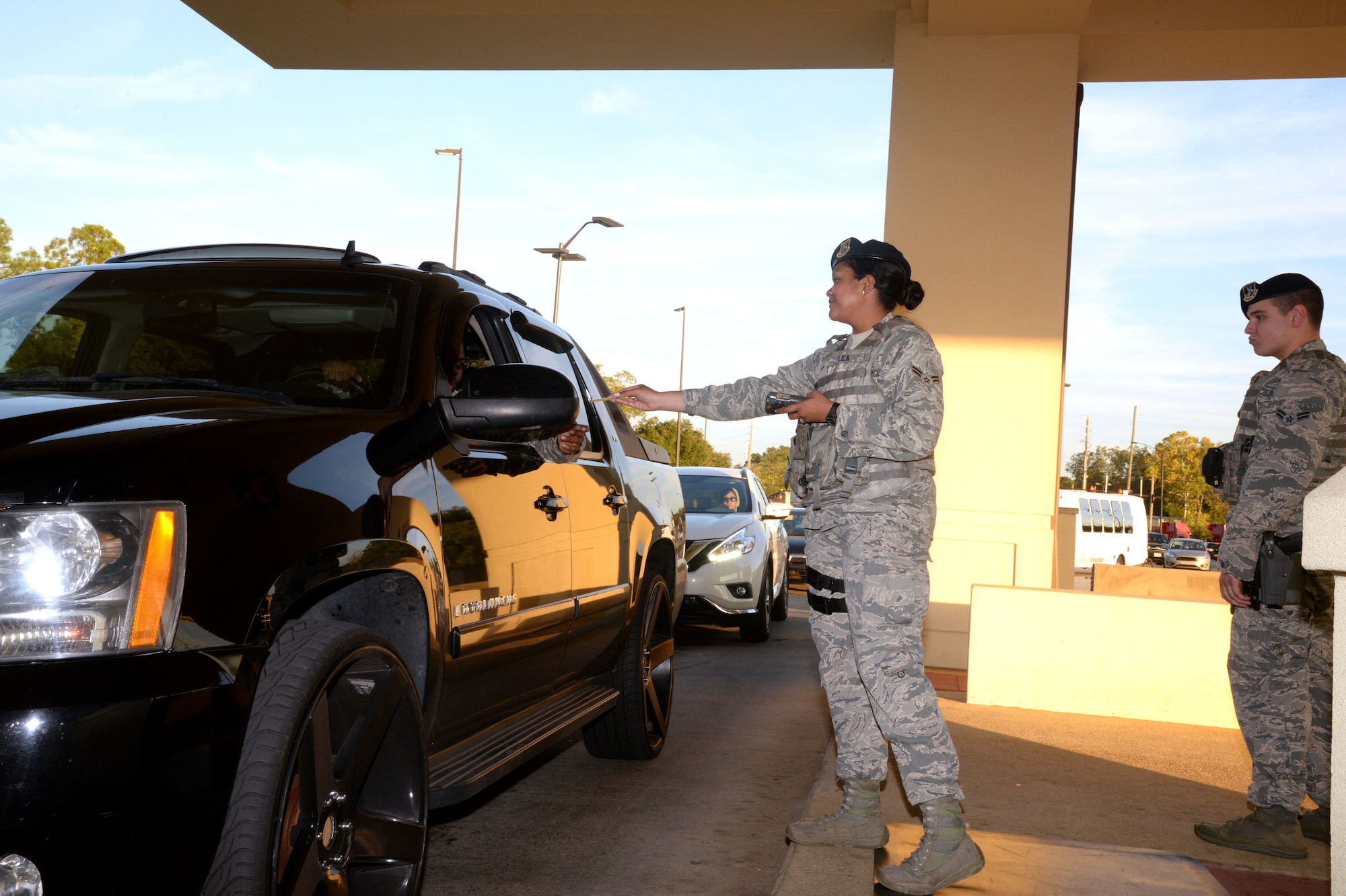 Members of the 42nd Air Base Wing security forces check I.D. at the front gate at Maxwell Air Force Base, Ala.  A recent change in base regulations now allows individuals who drive for ride-share services to now obtain a merchant pass.  