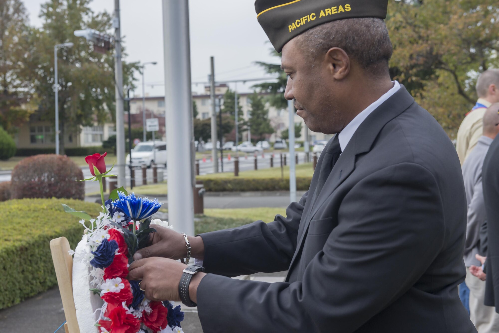 A member of the Veterans of Foreign Wars places a blue flower on a monument during the three flower ceremony at Yokota Air Base, Japan, Nov. 10, 2016. The three flowers each have a different meaning. The red rose represents those who have died in defense of their country, the white celebrates future service members and the blue immortalizes the deeds of soldiers, sailors, airmen and marines. (U.S. Air Force photo by Senior Airman David C. Danford/Released)