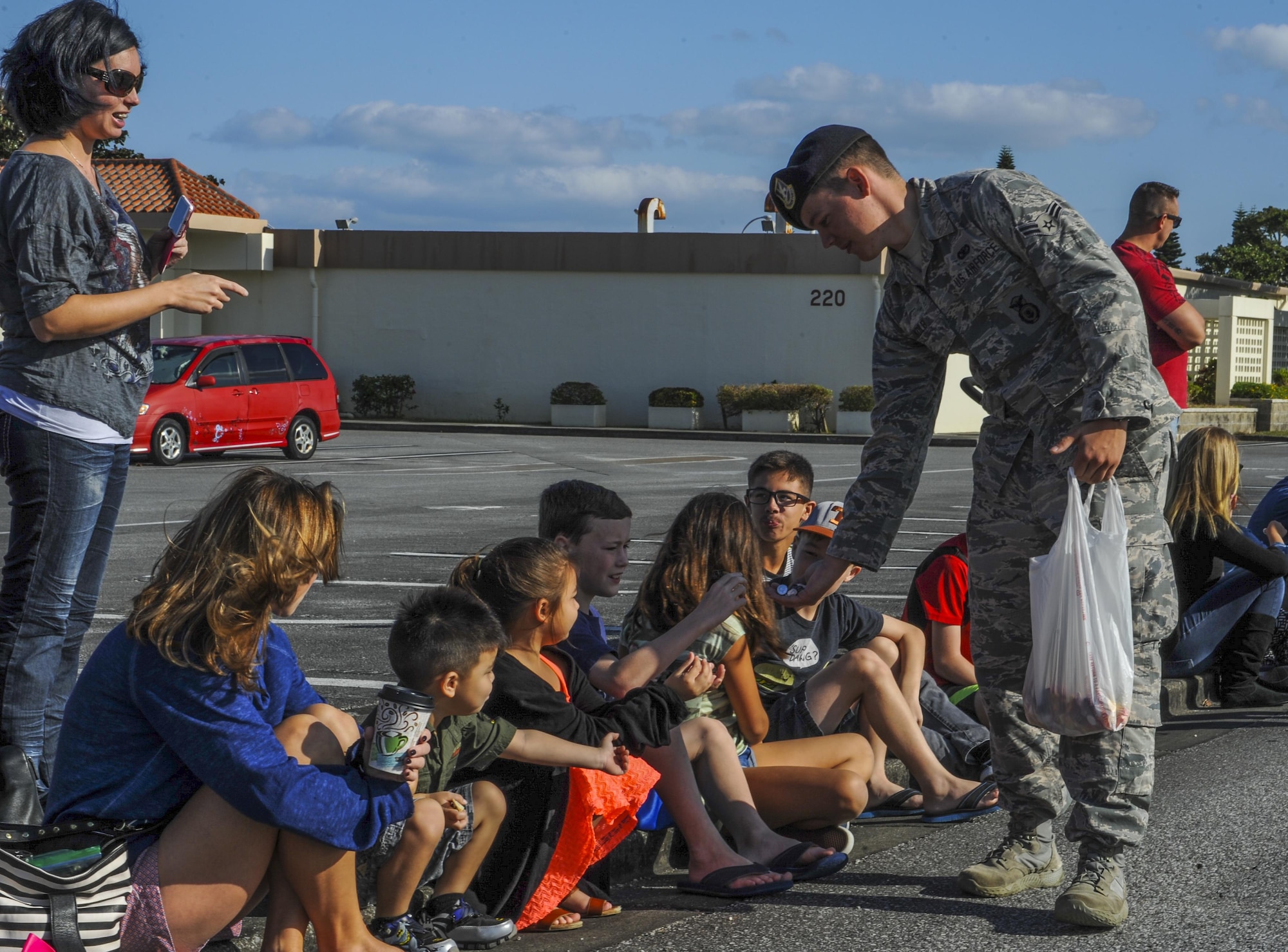 An Airman with the 18th Security Forces Squadron passes out candy for the Veterans Day parade, Nov. 11, 2016 on Kadena Air Base, Japan. Veterans Day is a day to remember and celebrate all that veterans have done and are currently doing for the United States of America. (U.S. Air Force photo by Airman 1st Class Nick Emerick/Released)