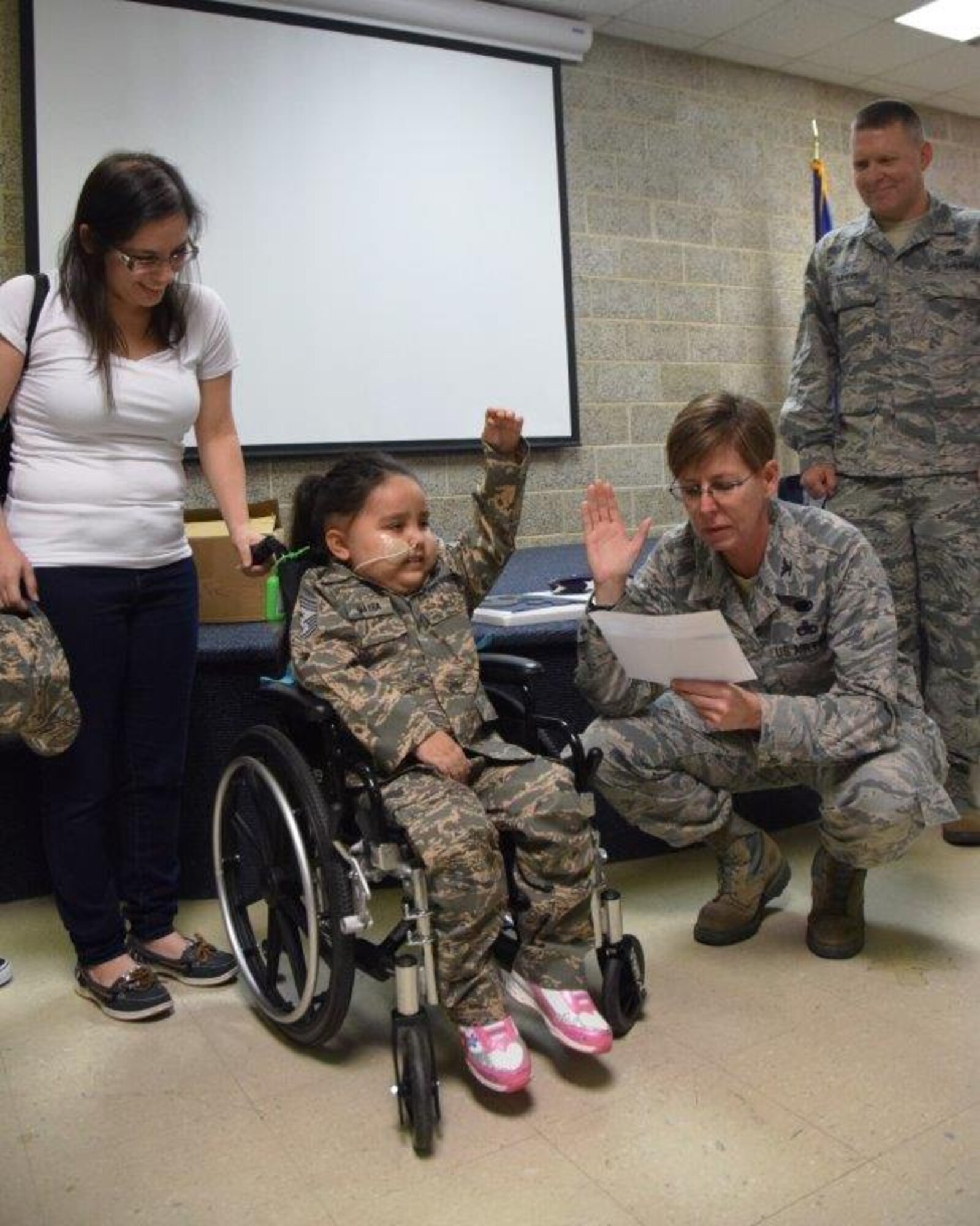 Col. Gretchen Wiltse, right, 433rd Maintenance Group commander, administers a military oath to 5-year-old Mayra Salinas, while the child's mother, Ashley Salinas, observes,  Nov. 5, 2016 at Joint Base San Antonio-Lackland, Texas. Salinas became an honorary member of the Rising 6, a private organization at the 433rd Airlift Wing comprised of Airmen in the grade of E-1 to E-6. (U.S. Air Force photo/Tech. Sgt. Carlos J. Treviño)