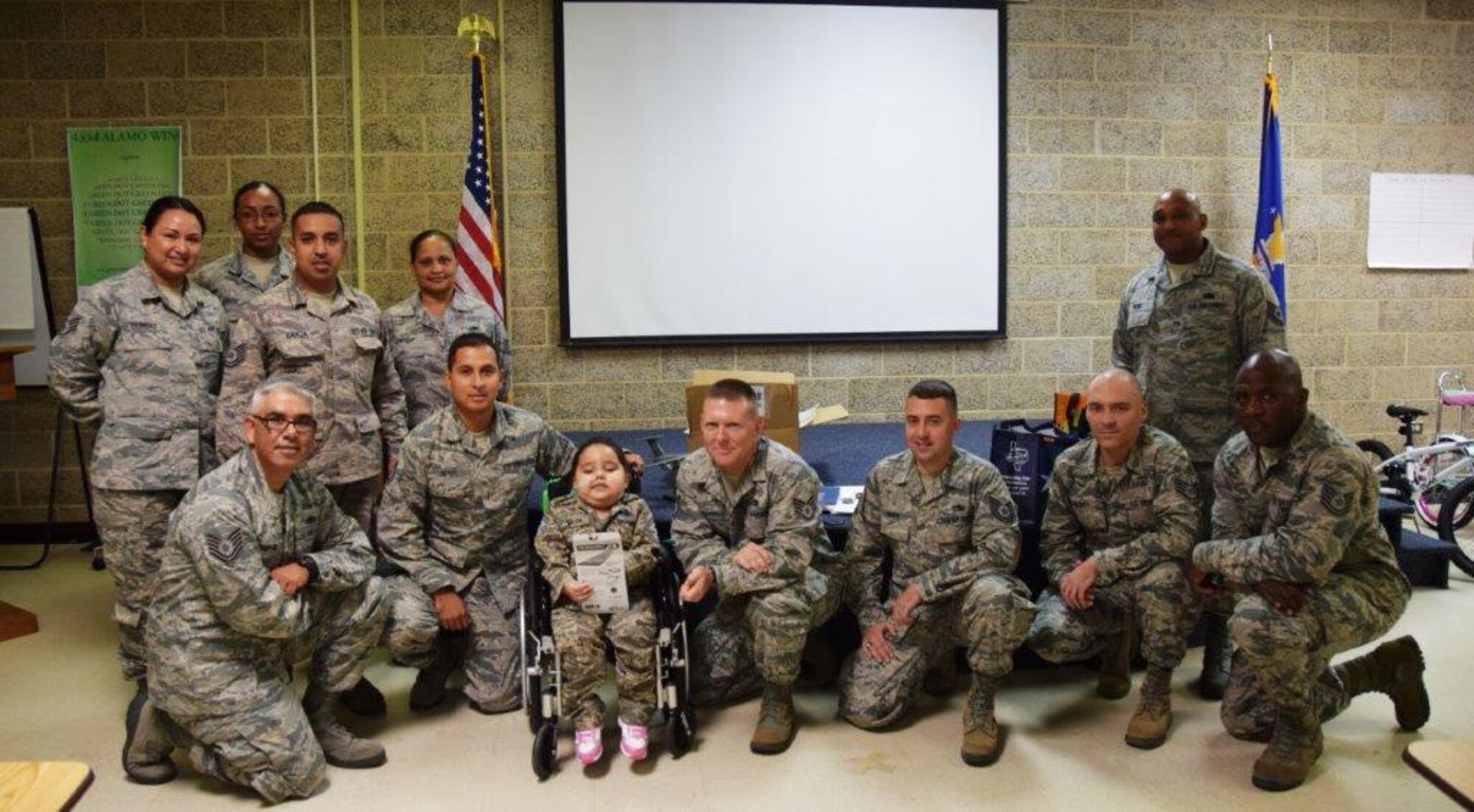 Five-year-old Mayra Salinas, center, poses with members of the 433rd Airlift Wing Rising 6, after being inducted into the group Nov. 5, 2016 at Joint Base San Antonio-Lackland, Texas. Salinas and her family spent the day with members of the Rising 6, visiting the Alamo Wing and getting an up-close look at the C-5M Super Galaxy. The Rising 6 is a private organization comprised of Airmen grades E-1 through E-6. (U.S. Air Force photo/Tech. Sgt. Carlos J. Treviño)