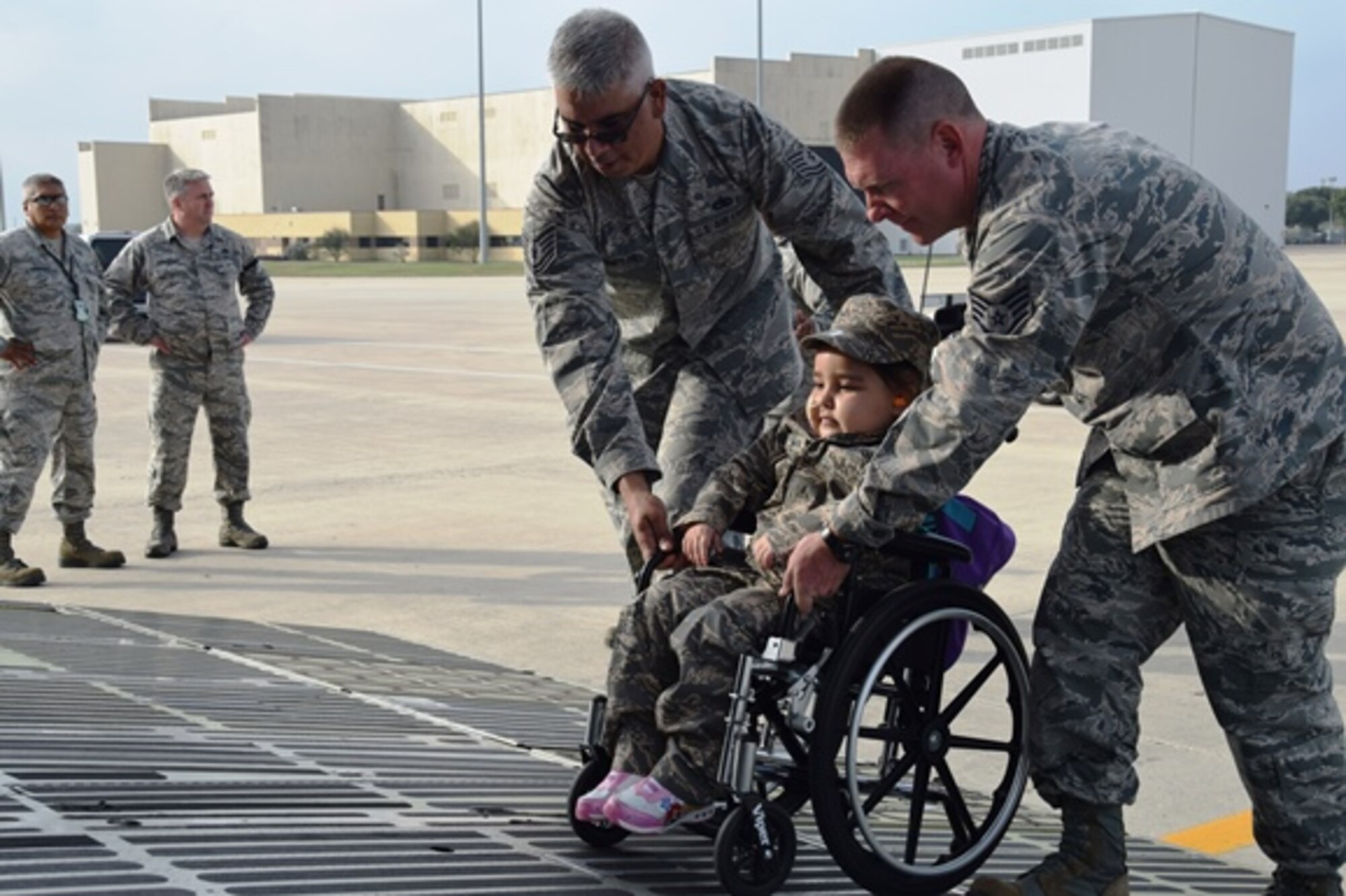 Tech. Sgt. Ernesto Compean, left, and Staff Sgt. Timothy McKay, right, Rising 6 members from the 433rd Aircraft Maintenance Squadron, help 5-year-old Mayra Salinas onto the front loading ramp of a C-5M Super Galaxy Nov. 5, 2016 at Joint Base San Antonio-Lackland, Texas. Mayra was chosen to be the Rising 6 Airman for the Day. The Rising 6 is a private organization comprised of Airmen grade E-1 through E-6. (U.S. Air Force photo/Tech. Sgt. Carlos J. Treviño)
