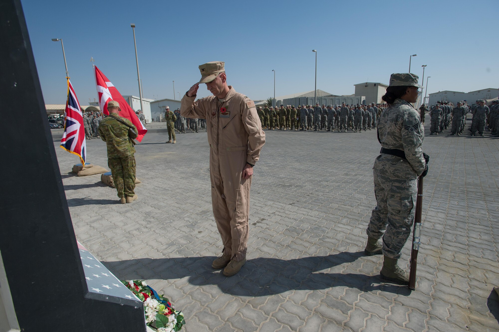 Col. Kevin, 380 Air Expeditionary Wing vice commander, honors the lives of fallen service members during a Coalition Veteran’s Day ceremony on Nov. 11, 2016 at an undisclosed location in Southwest Asia. After the laying of wreaths, a Royal Australian Air Force chaplain led service members in a reciting of The Ode, a segment of a poem written by Laurence Binyon in 1914. (U.S. Air Force photo by Senior Airman Tyler Woodward)

