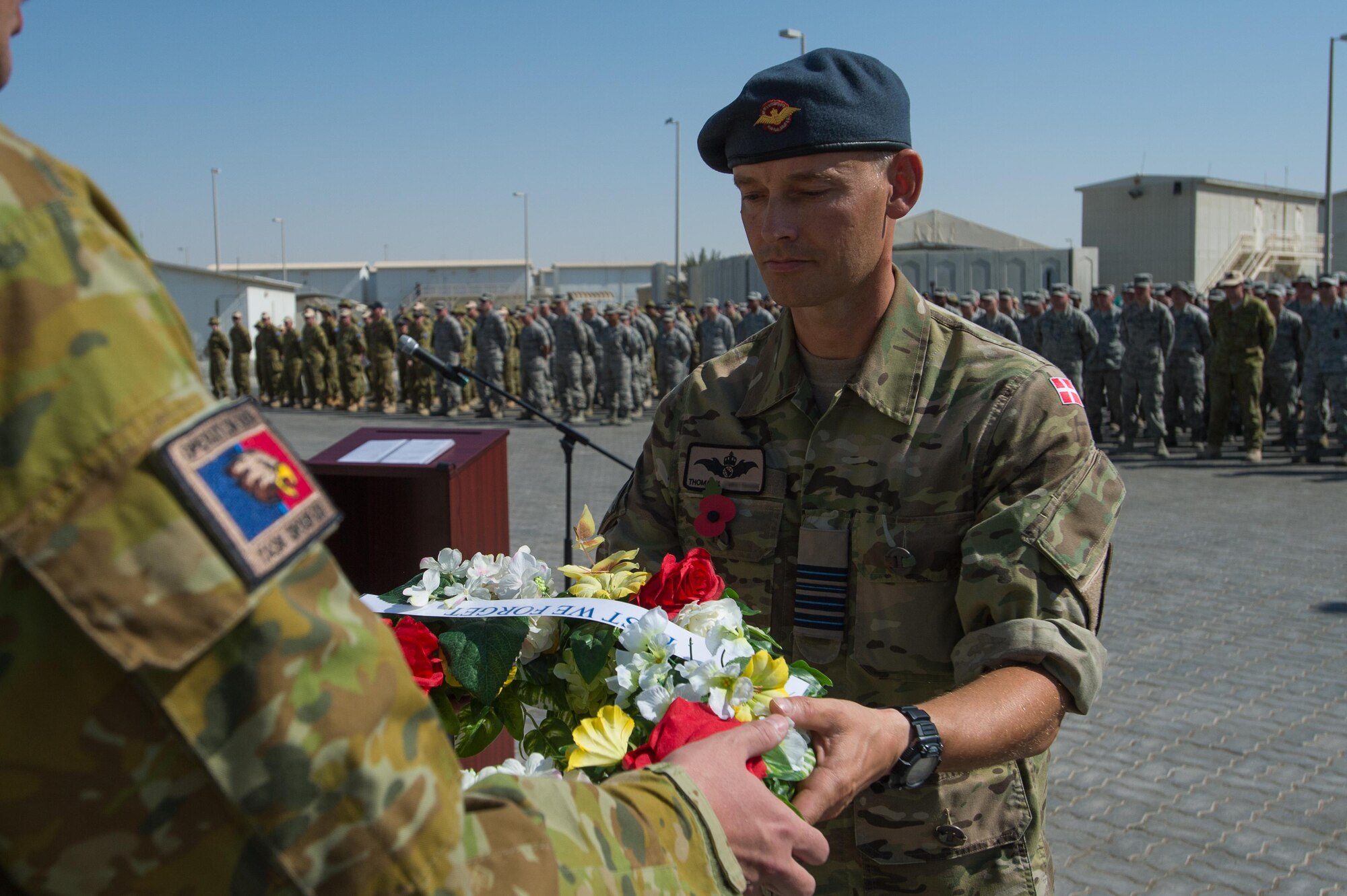 A deployed Royal Danish Air Force service member receives a wreath during a Coalition Veteran’s Day ceremony on Nov. 11, 2016 at an undisclosed location in Southwest Asia. The wreaths were placed at a nearby memorial in honor of fellow veterans. (U.S. Air Force photo by Senior Airman Tyler Woodward)