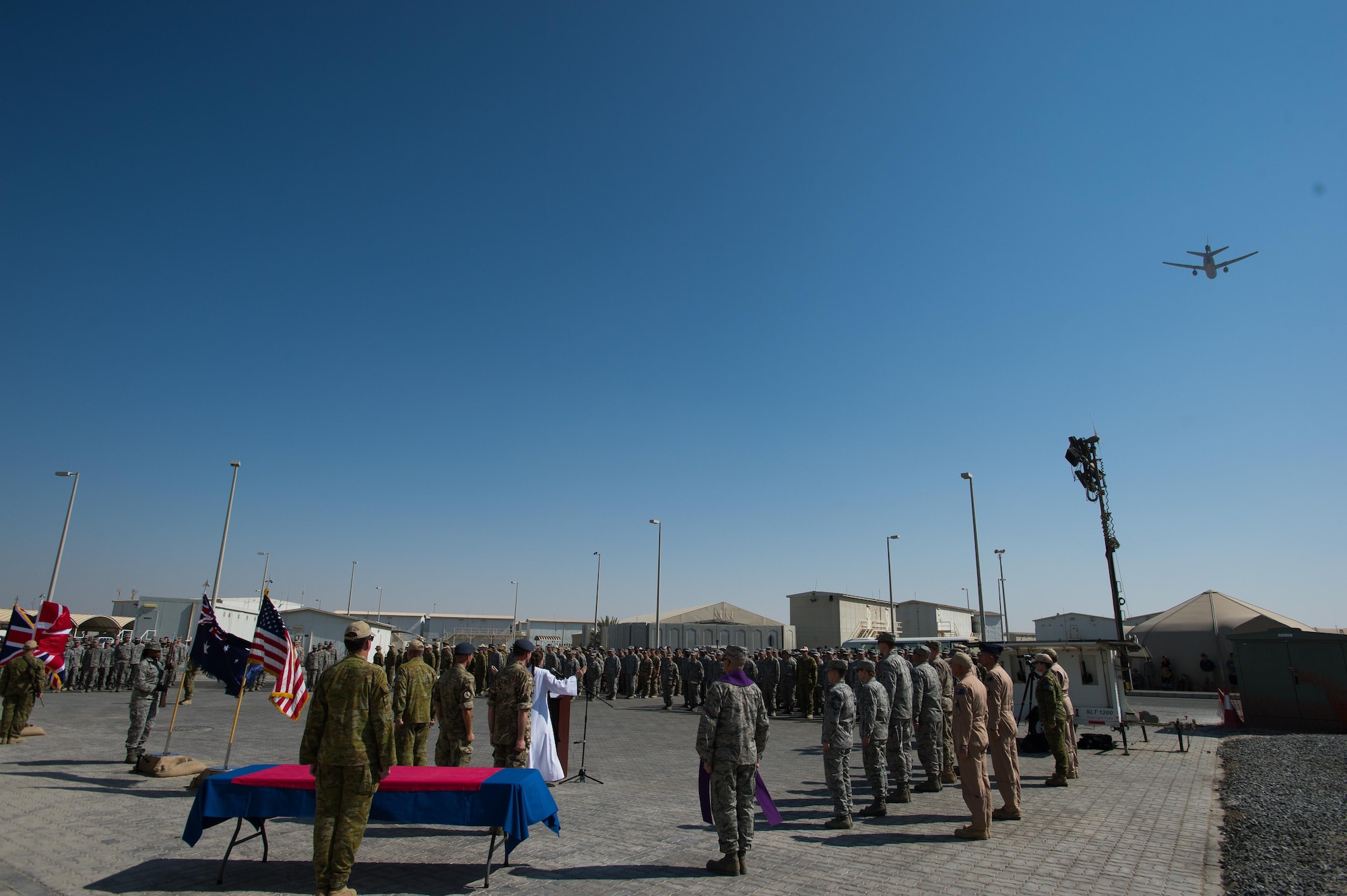 During the closing segments of a joint Veteran’s Day ceremony, a KC-10 Extender completes a fly-over, Nov. 11, 2016 at an undisclosed location in Southwest Asia. A combination of prayers, readings and moments of reflection provided deployed coalition nations the opportunity to memorialize the annual holiday. (U.S. Air Force photo by Senior Airman Tyler Woodward)