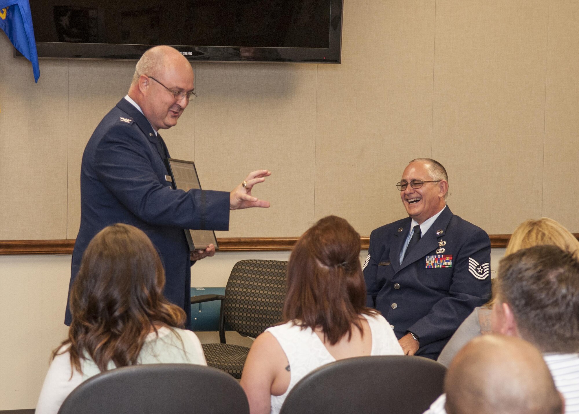 U.S. Air Force Tech. Sgt. Paul Motter, 307th Operations Support Squadron, laughs as he is presented a Styx album from Col. David Webb, Chief of Combat Operations for the 608th Air Operations Center, to represent their common interest in music at his retirement on Nov. 5, 2016, Barksdale Air Force Base, La. Motter is assigned to the 307th Operations Support Squadron and is retiring after 33 years of military service. (U.S. Air Force photo by Tech. Sgt. Cody Burt/Released)