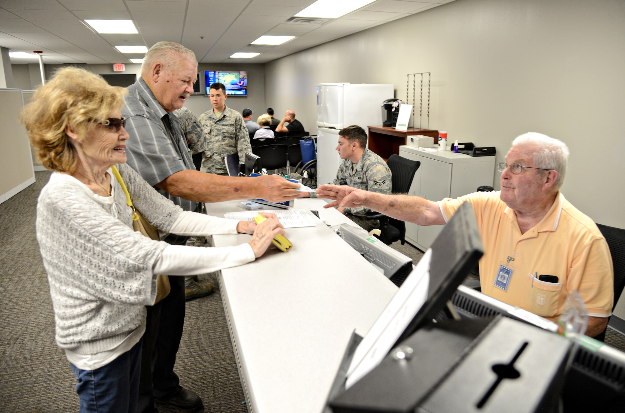 Lee Dickey, a volunteer with the 72nd Force Support Squadron’s Military Personnel Section, helps customers check in at the new location for the CAC/ID Card Office in Bldg. 1. In addition to CAC and ID cards, the members of the Military Personnel Section can also update DEERS information and SGLI, do In-processing/Gains and LeaveWeb. (Air Force photo by Kelly White)