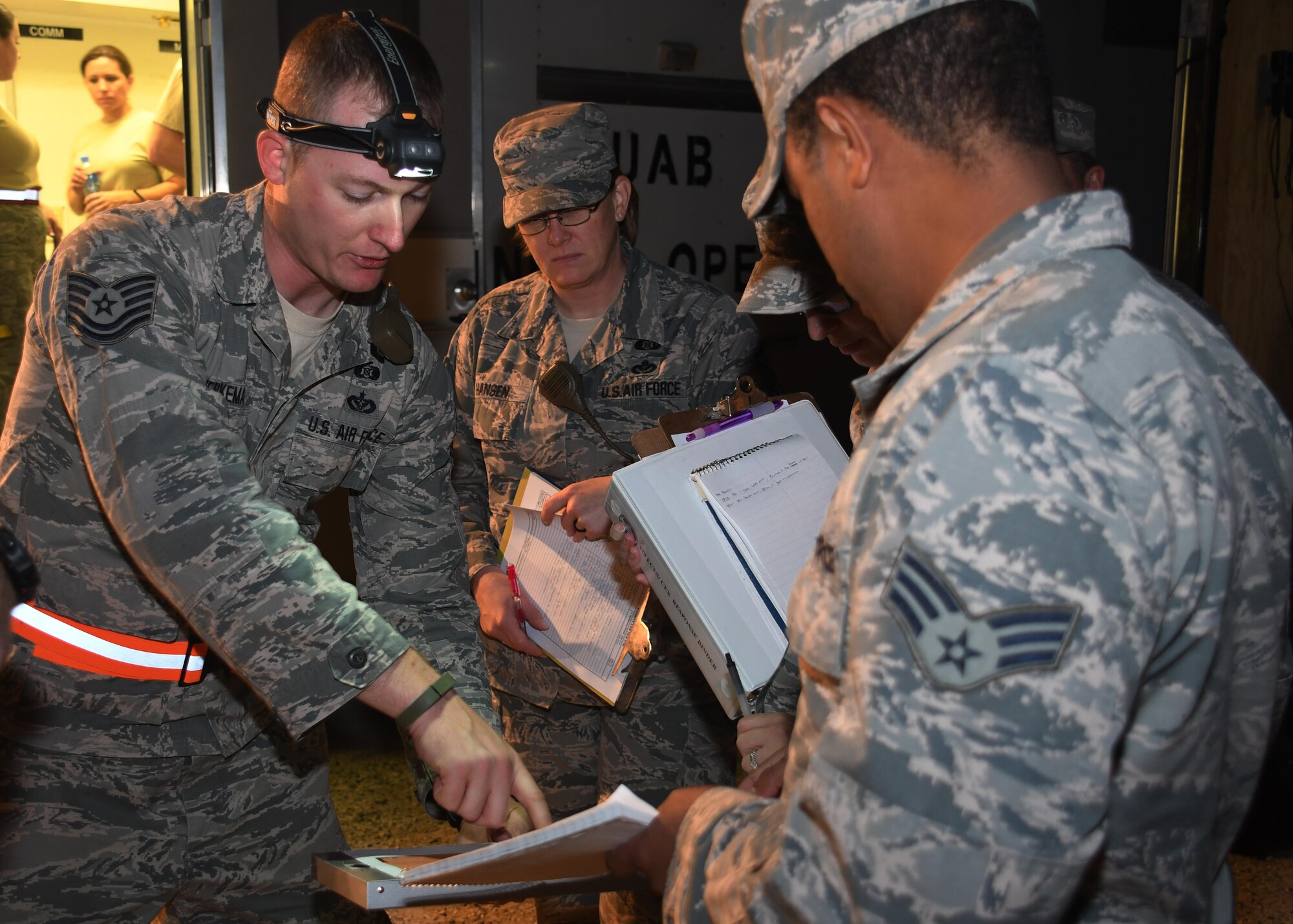 Members of the 379th Expeditionary Civil Engineer Squadron Emergency Management Flight coordinate strategies to to approach a package suspected of posing a radiological threat during an exercise at Al Udeid Air Base, Qatar, Nov. 9, 2016. The members participated in a multi-agency exercise that involved a simulated Radiological Dispersal Device. (U.S. Air Force photo by Senior Airman Miles Wilson)