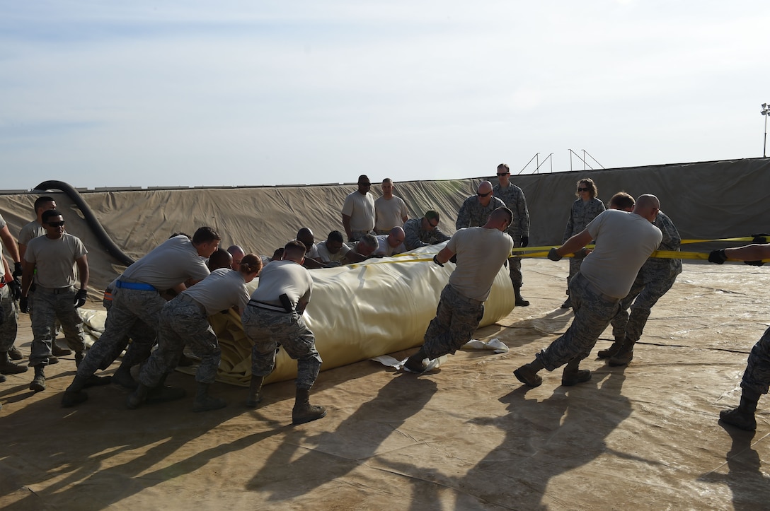 Members throughout the 380th Expeditionary Logistics Readiness Squadron joined the Fuel Management Flight to roll out a new fuel bladder at an undisclosed location in Southwest Asia, Nov. 9, 2016. This 210,000 gallon bladder will be part of the largest fuel bladder farm in the U.S. Air Forces Central Command area of responsibility. (U.S. Air Force photo by Tech. Sgt. Christopher Carwile)