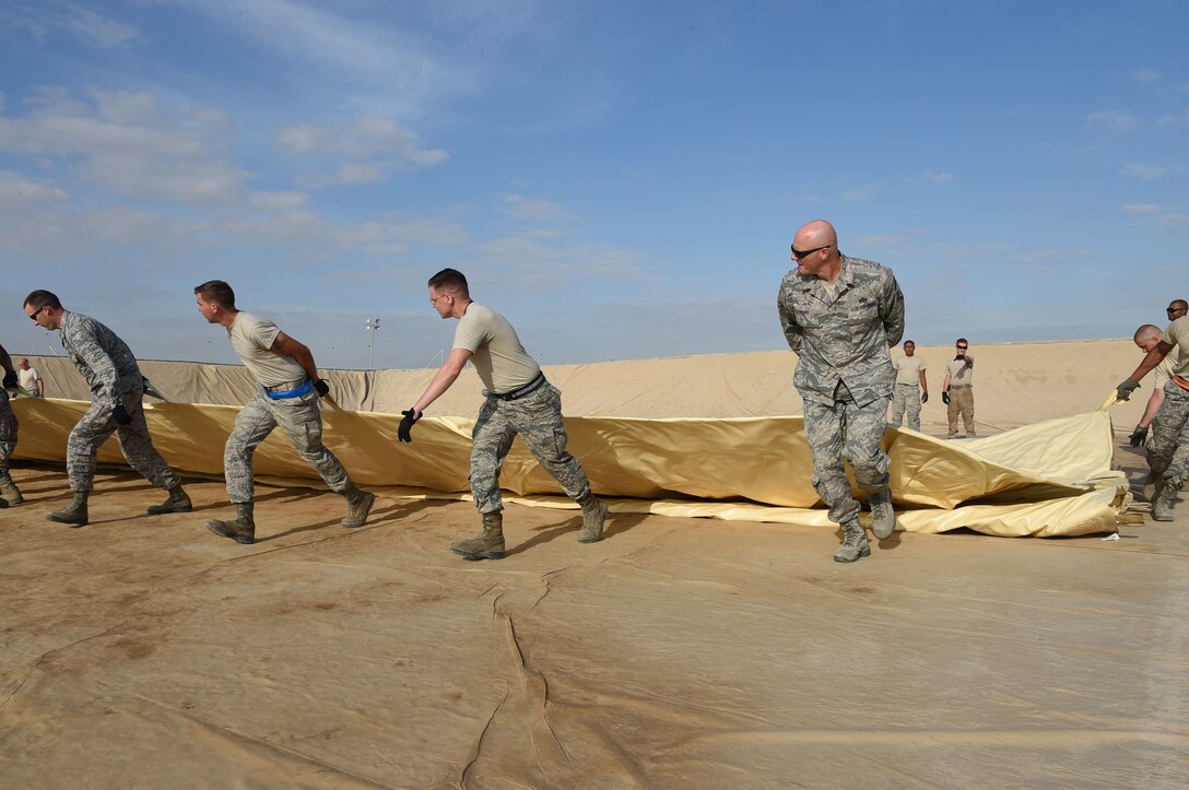 The 380th Expeditionary Logistics and Readiness Squadron come together to lay out a new 210,000 gallon fuel bladder at an undisclosed location in Southwest Asia, Nov. 9, 2016. The Fuels Management Flight maintains 27 bladders and two underground tanks holding JP-8 jet fuel in addition to other bladders and tanks containing five other fuels. (U.S. Air Force photo by Tech. Sgt. Christopher Carwile)