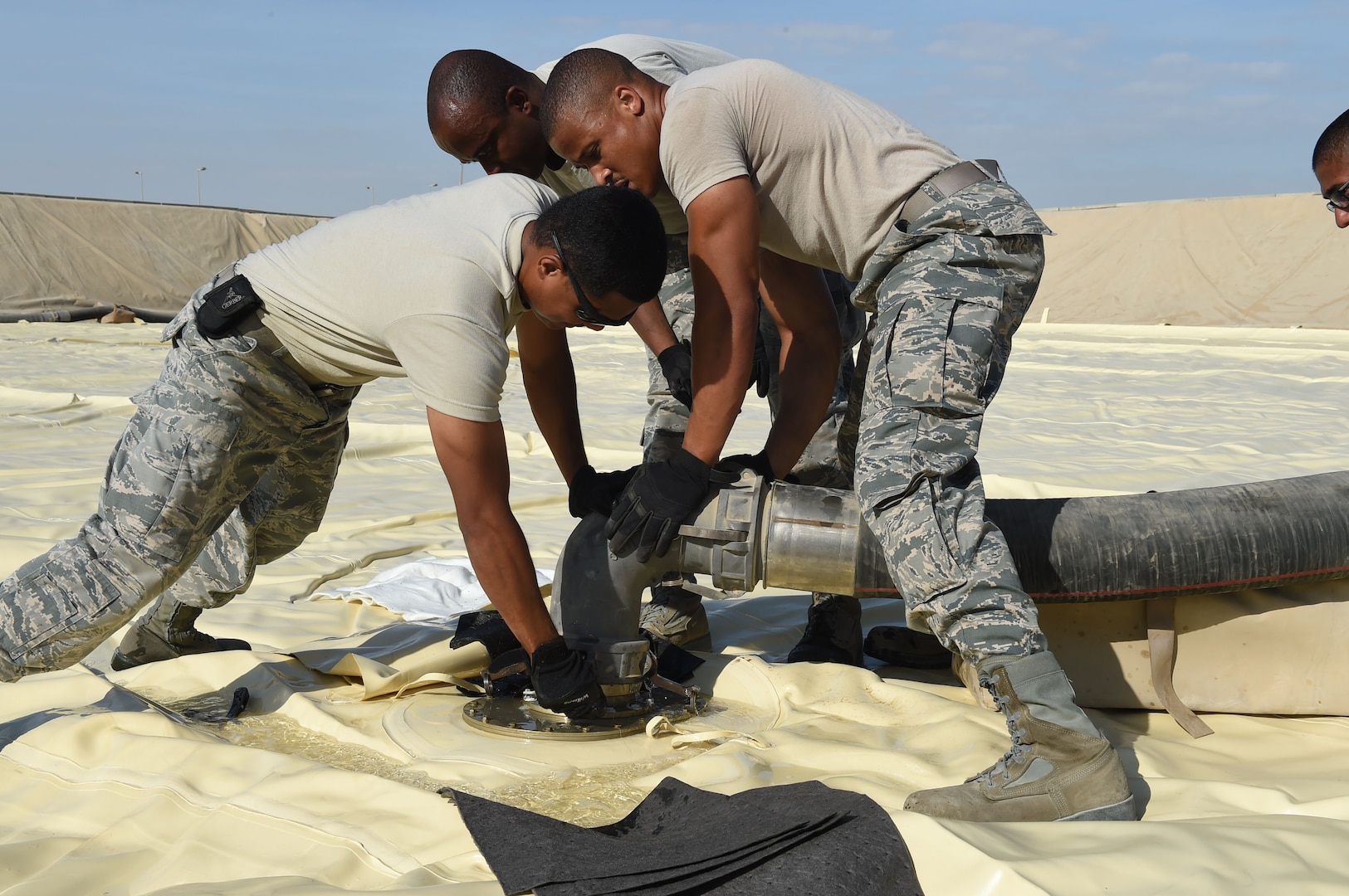 380th Fuels Management Flight members latch a fuel hose onto the new JP-8 jet fuel bladder that was installed at an undisclosed location in Southwest Asia, Nov. 9, 2016. This bladder will hold 210,000 gallons of jet fuel once fully connected, becoming part of a network of 27 similar bladders providing fuel to the 380th Air Expeditionary Wing flying mission. (U.S. Air Force photo by Tech. Sgt. Christopher Carwile)