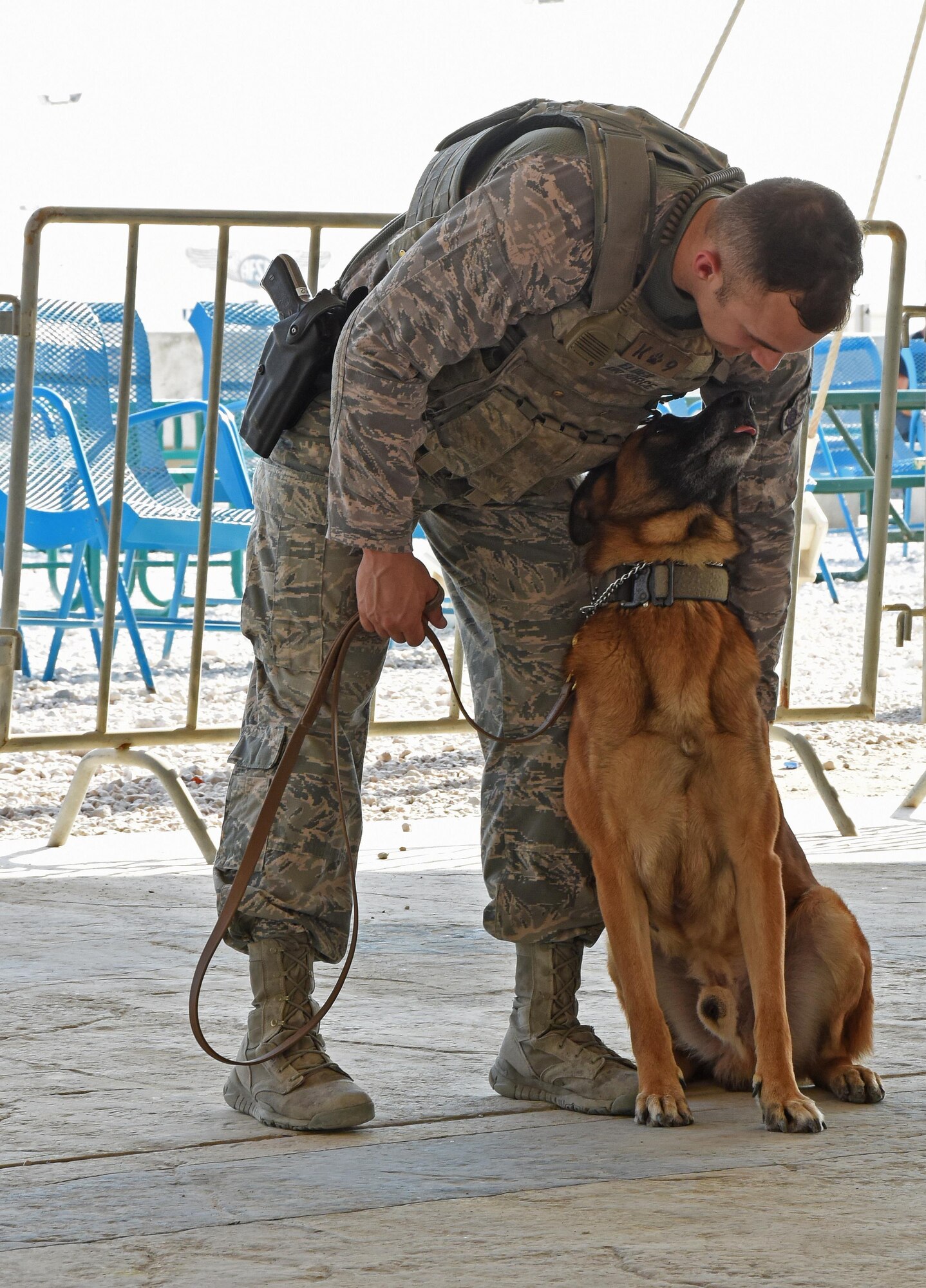U.S. Air Force Senior Airman Jonathan Elder, a dog handler with the 379th Expeditionary Security Forces Squadron military working dog section, pets his assigned canine, Miki, during a Veterans Day MWD demonstration at Al Udeid Air Base, Qatar, Nov. 11, 2016. MWD handlers train with their canine partners daily to maintain basic skills. (U.S. Air Force photo by Senior Airman Cynthia A. Innocenti)
