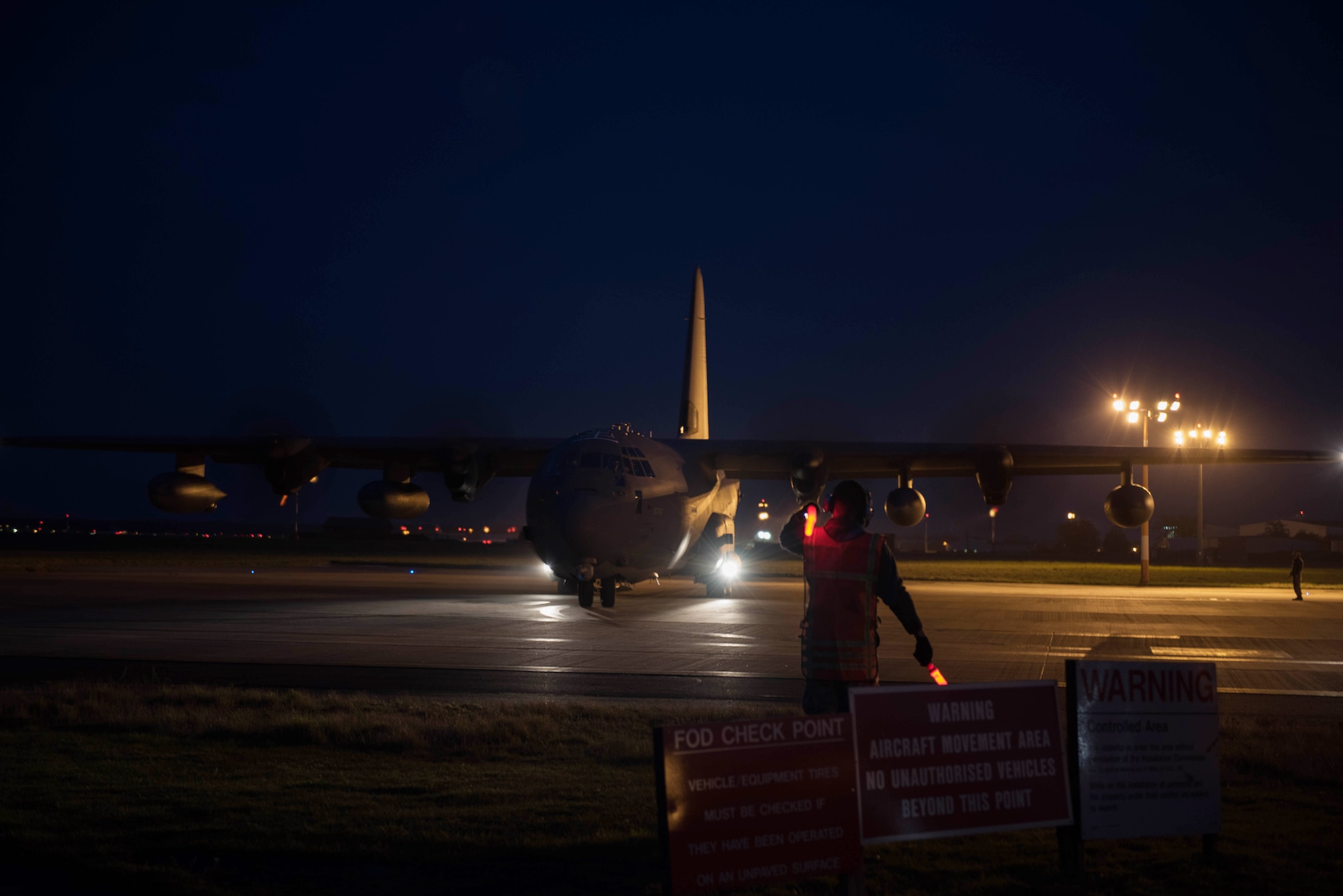 A U.S. Airman from the 352d Special Operations Aircraft Maintenance Squadron, marshals an MC-130J Commando II on RAF Mildenhall, Nov. 3, 2016. The multi-role special operations aircraft primarily flies missions at night to reduce probability of visual acquisition and intercept by airborne threats. (U.S. Air Force photo by 1st Lt Chris Sullivan)