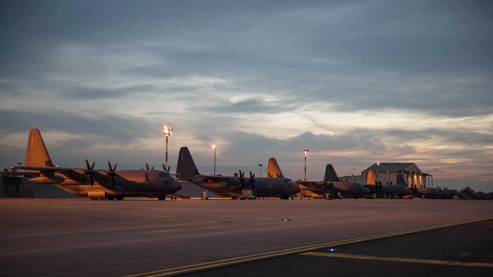 The sun sets over a fleet of MC-130J Commando II’s on RAF Mildenhall, Nov. 3, 2016.  The multi-role special operations aircraft, assigned to the 67th Special Operations Squadron flies clandestine, low-level air refueling missions for special operations helicopters and tiltrotor aircraft and infiltration, exfiltration and resupply of special operations forces by airdrop or airland intruding politically sensitive or hostile territories (U.S. Air Force photo by 1st Lt Chris Sullivan)