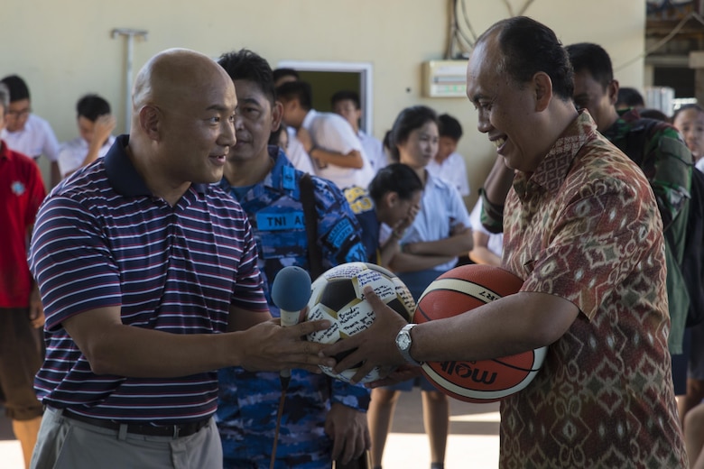U.S. Navy Lt. Cmdr. Philip Park, left, command chaplain with Marine Aircraft Group 12, gives Jemmy Jermias, the school principal, gifts from the Marines and Sailors with Marine All-Weather Fighter Attack Squadron (VMFA(AW)) 225 during a visit at Sekolah Menengah Eben Haezar Manado High School in Manado, Indonesia, Nov. 9, 2016. The exchanging of gifts symbolizes each other’s appreciation for cultural exchanges and community relations events. (U.S. Marine Corps photo by Cpl. Aaron Henson)