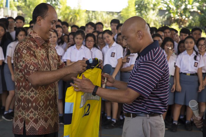U.S. Navy Lt. Cmdr. Philip Park, right, command chaplain with Marine Aircraft Group 12, recieves a school basketball jersey from Jemmy Jermias, the school principal, during a visit at Sekolah Menengah Eben Haezar Manado High School in Manado, Indonesia, Nov. 9, 2016. The exchanging of gifts symbolizes each other’s appreciation for cultural exchanges and community relations events. As part of a community relations event, the visit offered Marines and Sailors with Marine All-Weather Fighter Attack Squadron (VMFA(AW)) 225 the opportunity to engage in cultural exchanges and build relationships within the local community. (U.S. Marine Corps photo by Cpl. Aaron Henson)